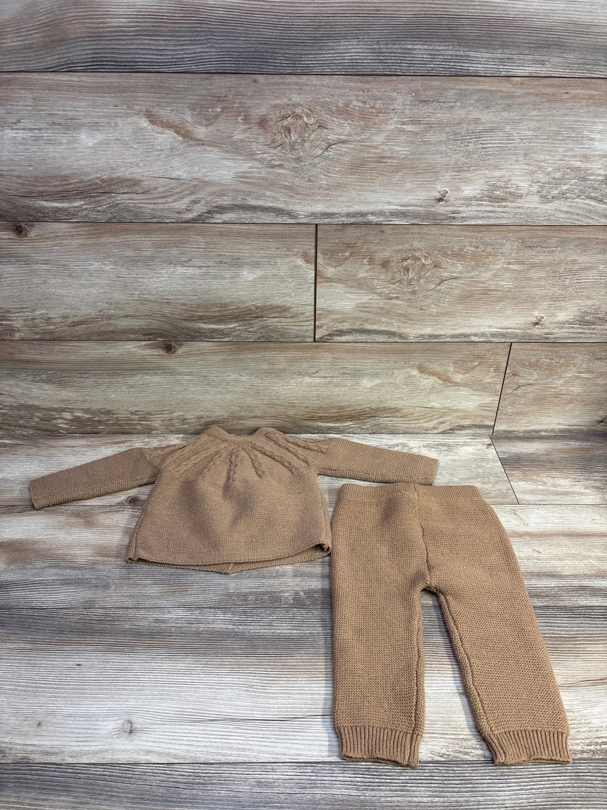 Flat lay of Arlo & Kai brown knit cardigan and pants set with long sleeves and ribbed cuffs on a wood background