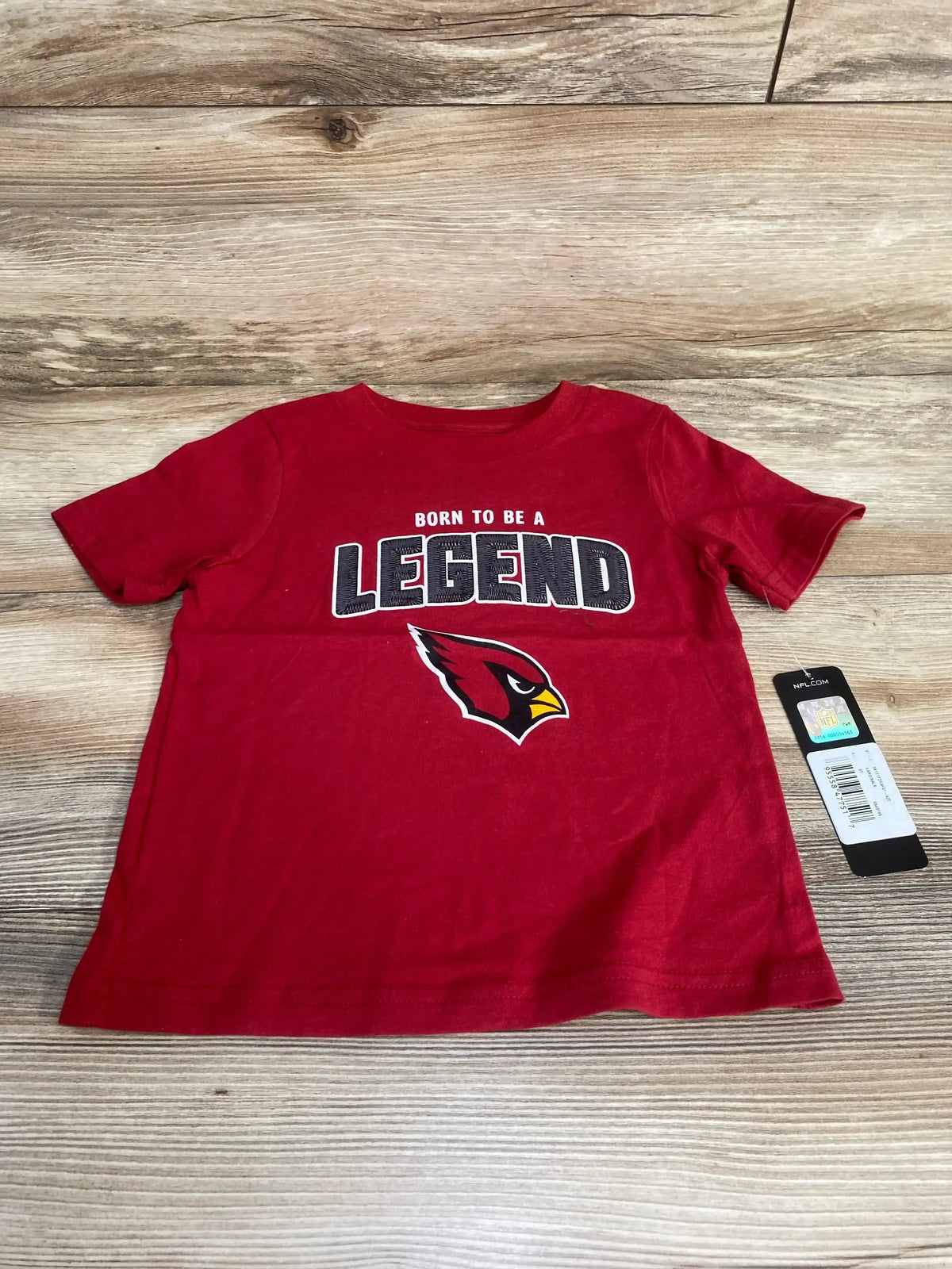 Flat front of red Arizona Cardinals T-shirt size 3T showing Born to Be a Legend text and Cardinals logo on wood background