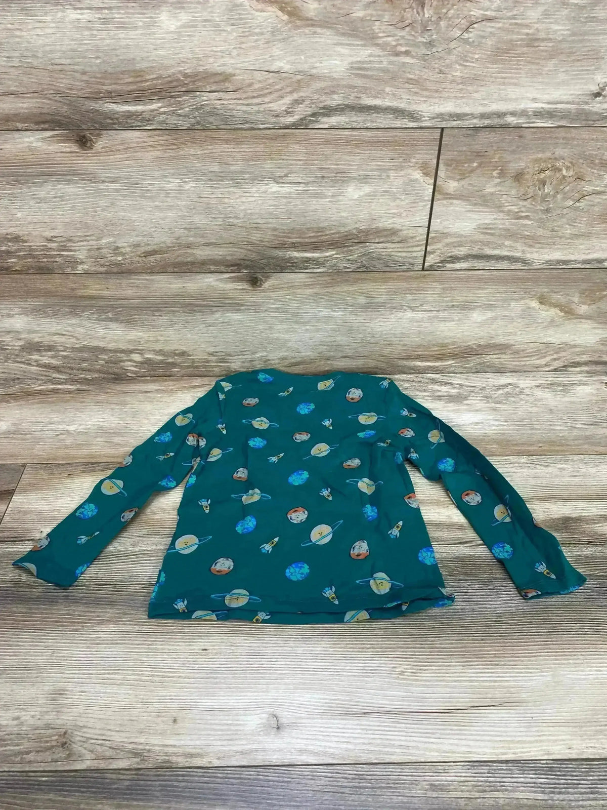 Flat lay of Old Navy green long-sleeve toddler shirt (size 5T) showing planet and rocket print on wood floor background