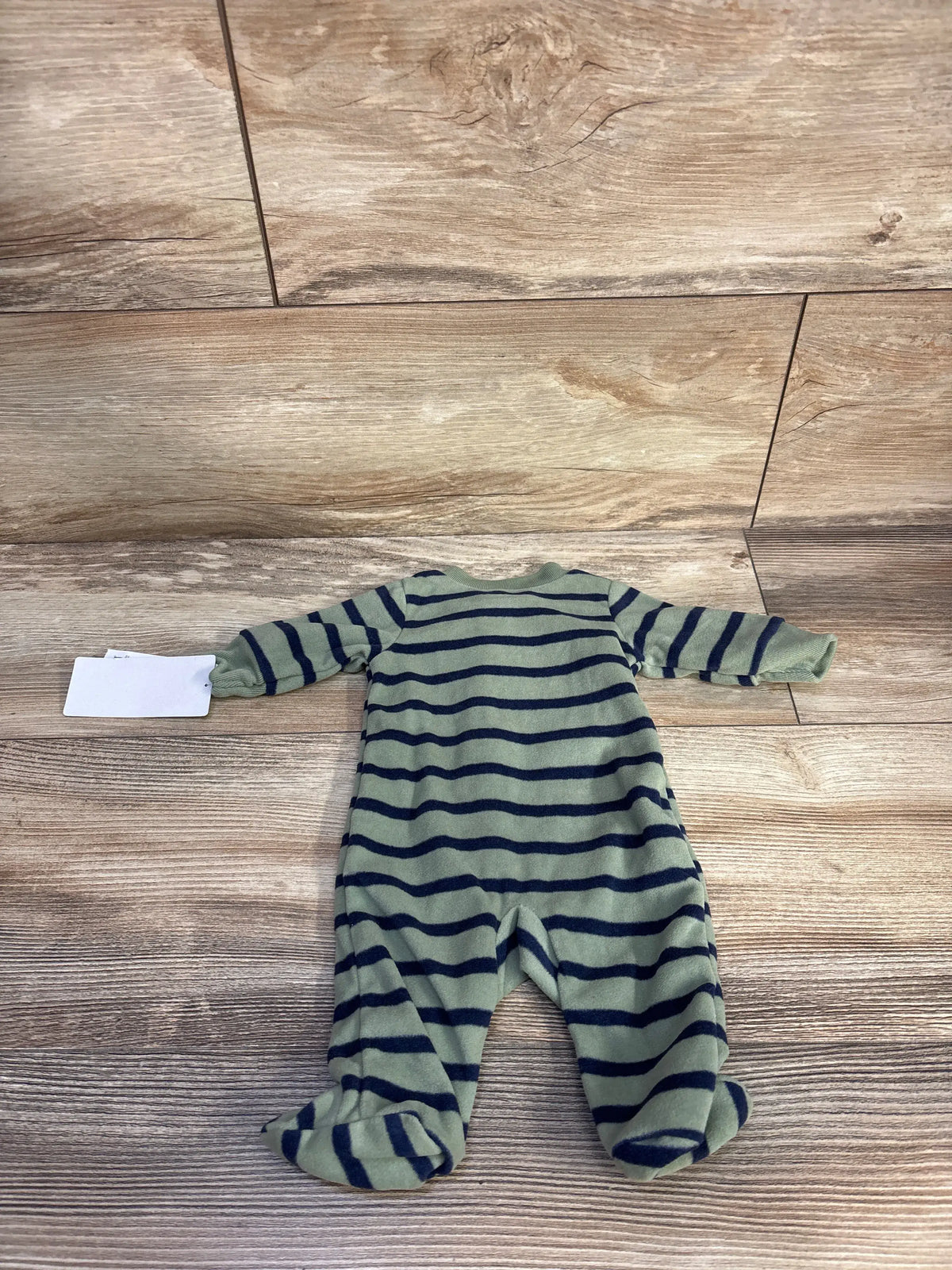 Flat lay of preemie green and navy striped footed sleeper with long sleeves and built in feet on wood floor