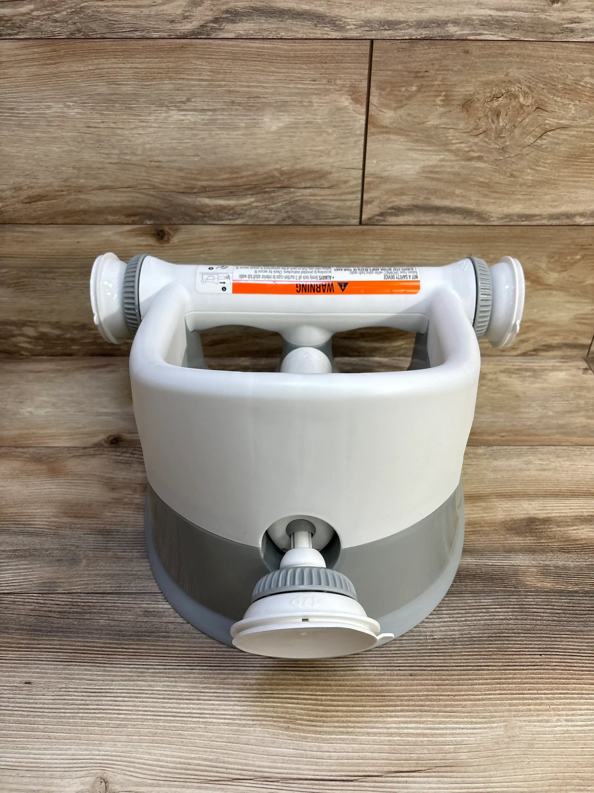 Top-front view of Summer Infant My Bath Seat in grey showcasing suction-cup base and contoured backrest on wood plank background