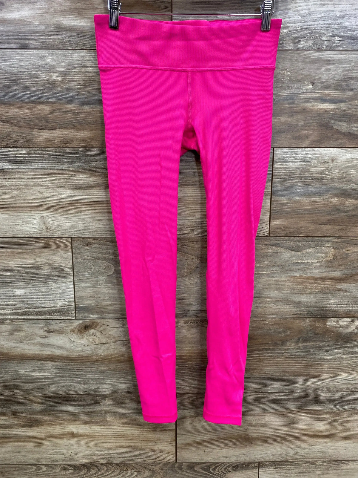Front view of NWOT Gap Fit maternity under belly rib blackout leggings hot pink size XS hanging on wood plank wall