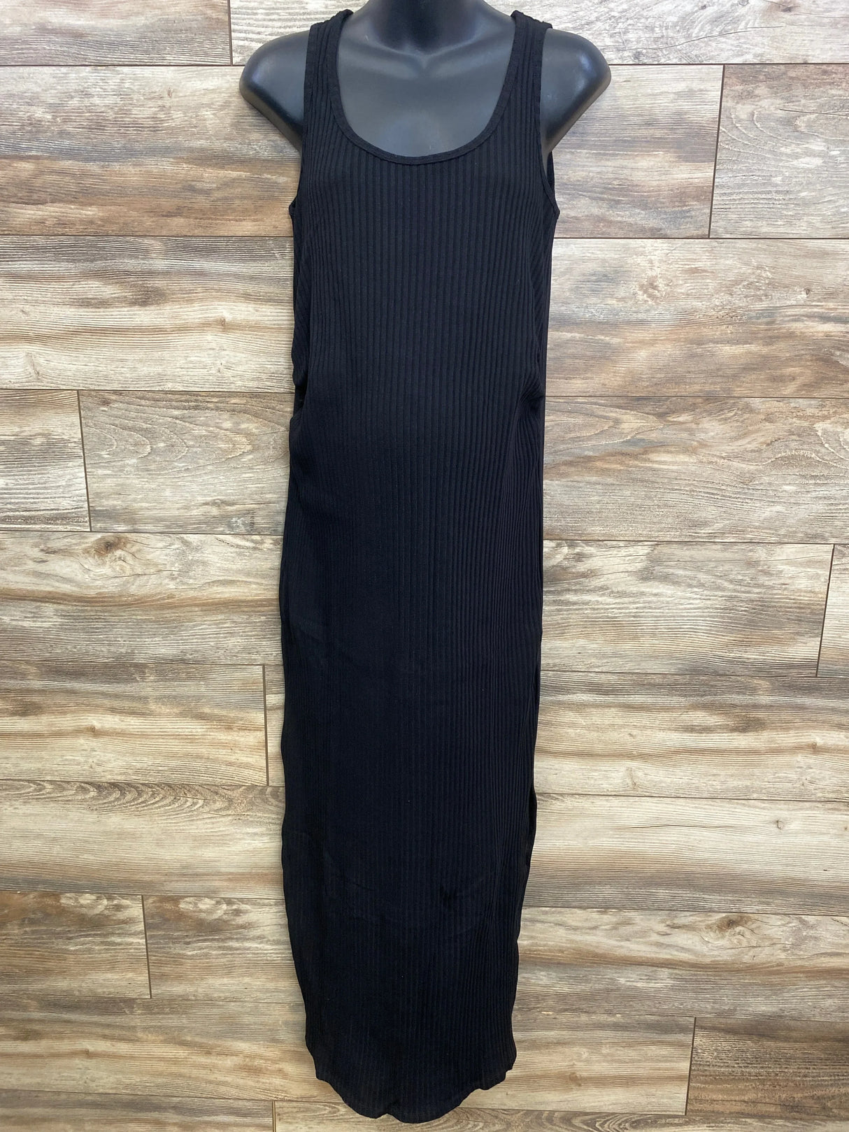 Front view of black Gap maternity ribbed maxi dress with scoop neckline, tank straps and vertical ribbing on wood background