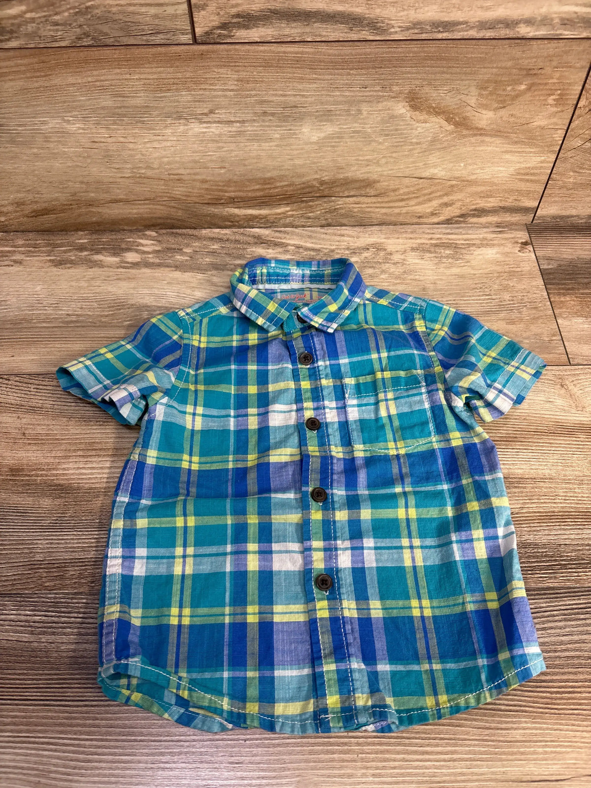 Front view of Cat & Jack blue button-up shirt showcasing plaid pattern and short sleeves on a wood floor