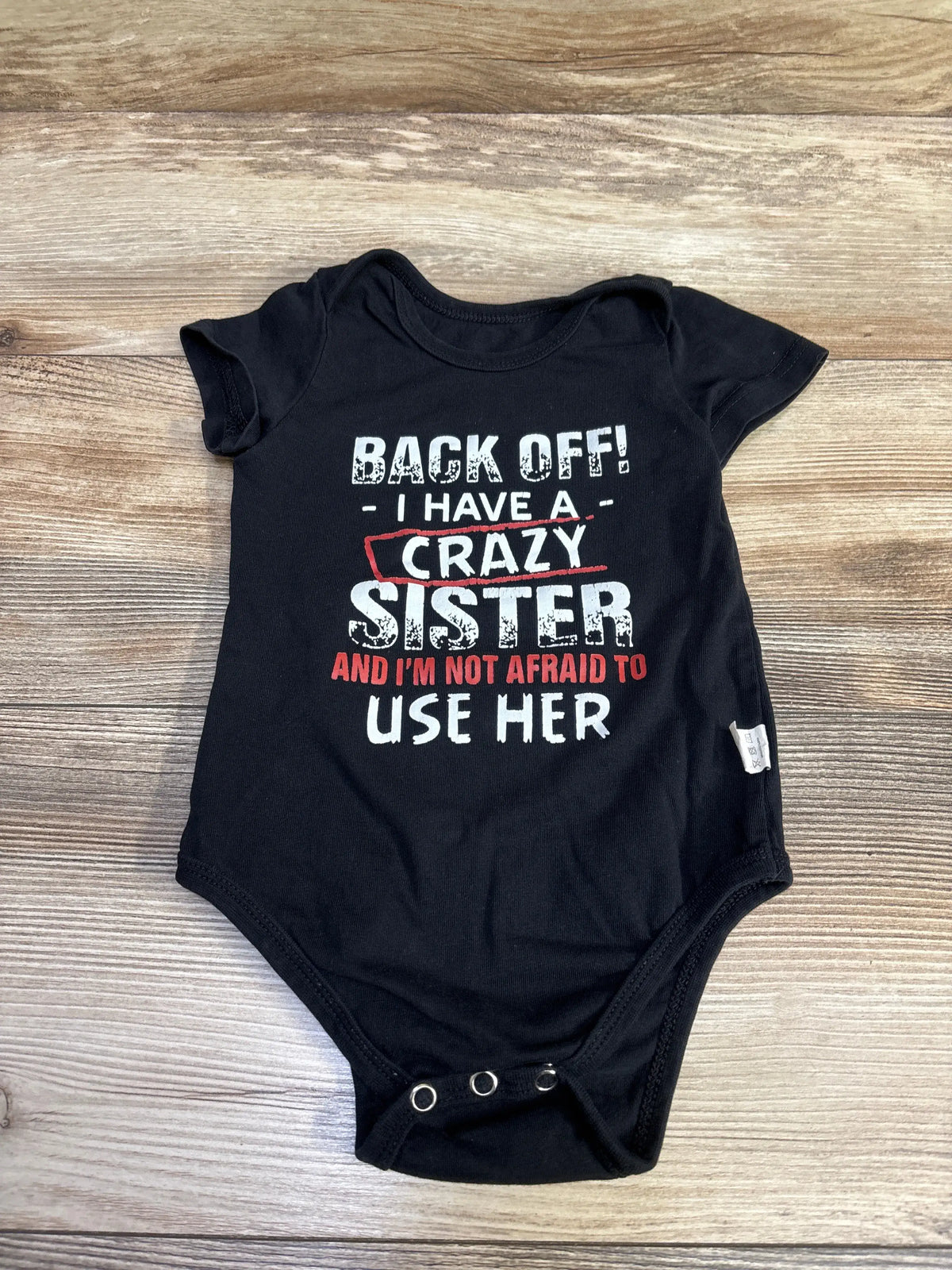 Black infant bodysuit with 'Back Off! I Have a Crazy Sister' printed in white and red text.