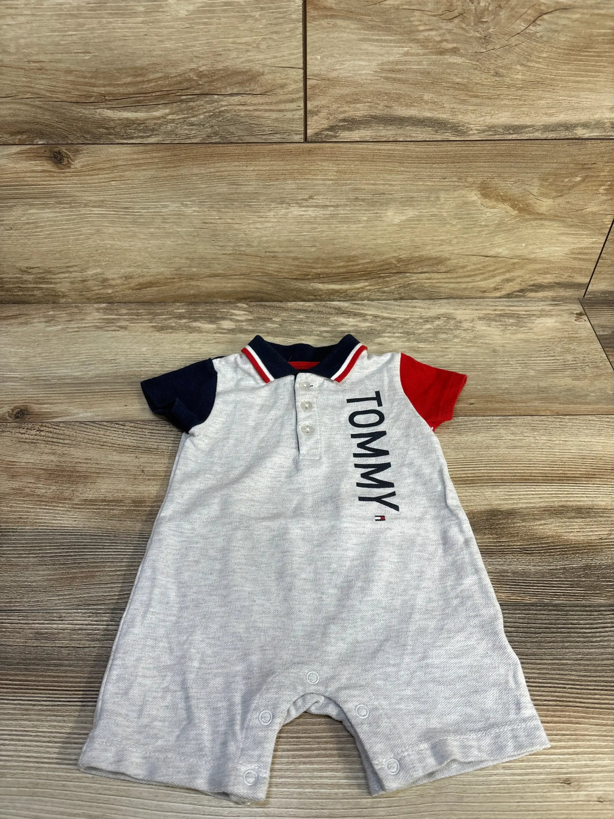 Front view of grey Tommy Hilfiger shortie romper (3–6 months) showcasing polo collar and snap crotch on white background