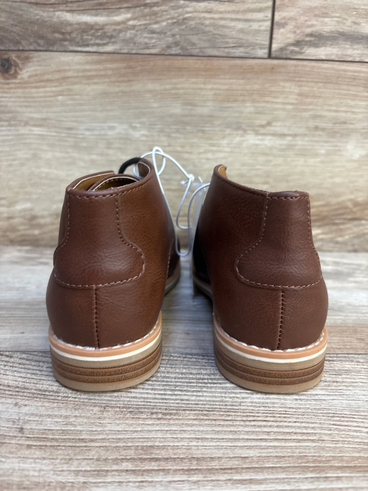 Back view of Cat & Jack Filip toddler brown leather boots showcasing stacked sole and laces on wood floor