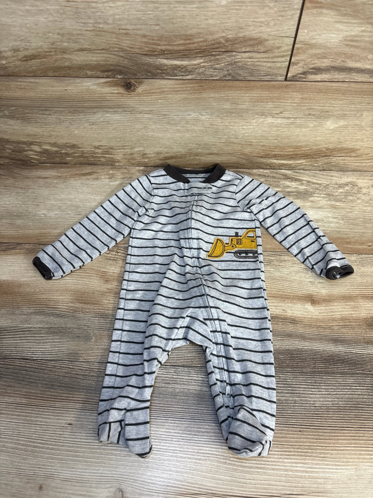Gray striped baby onesie with yellow bulldozer design, perfect for toddler sleepwear or playtime.