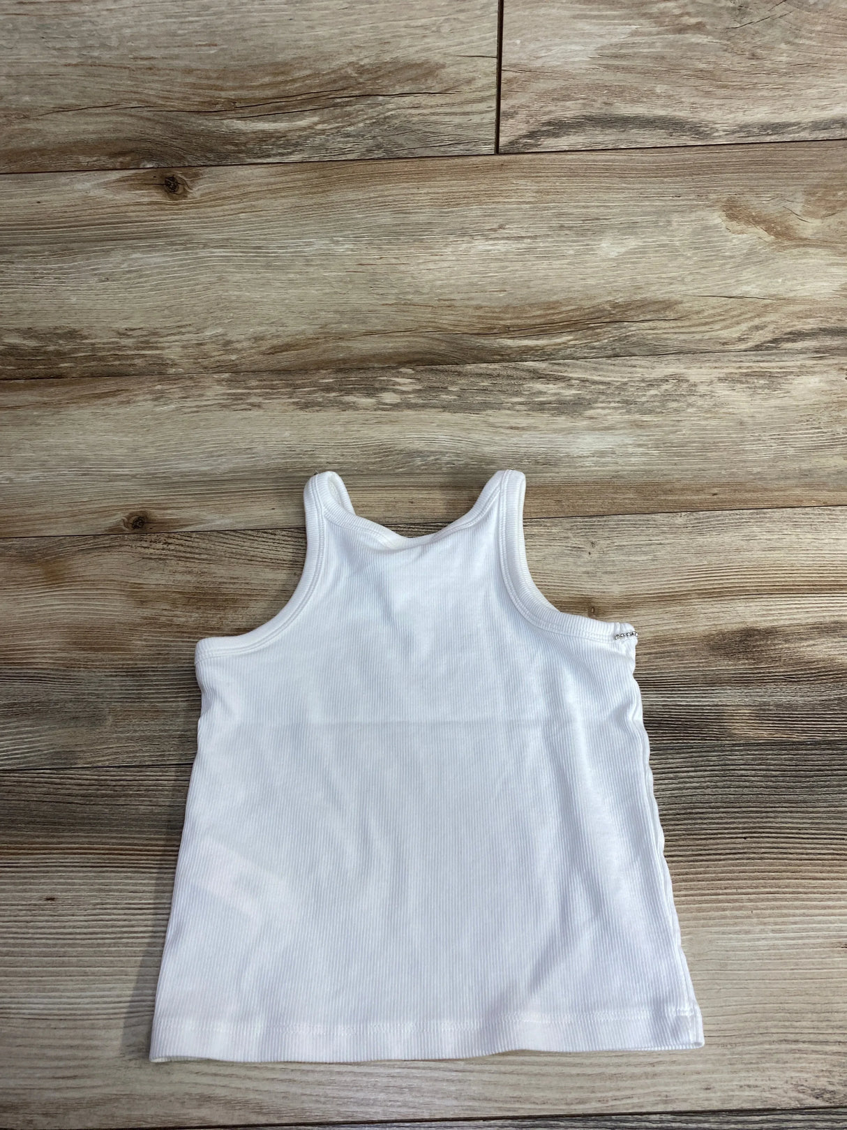 White ribbed sleeveless toddler tank top on wooden floor