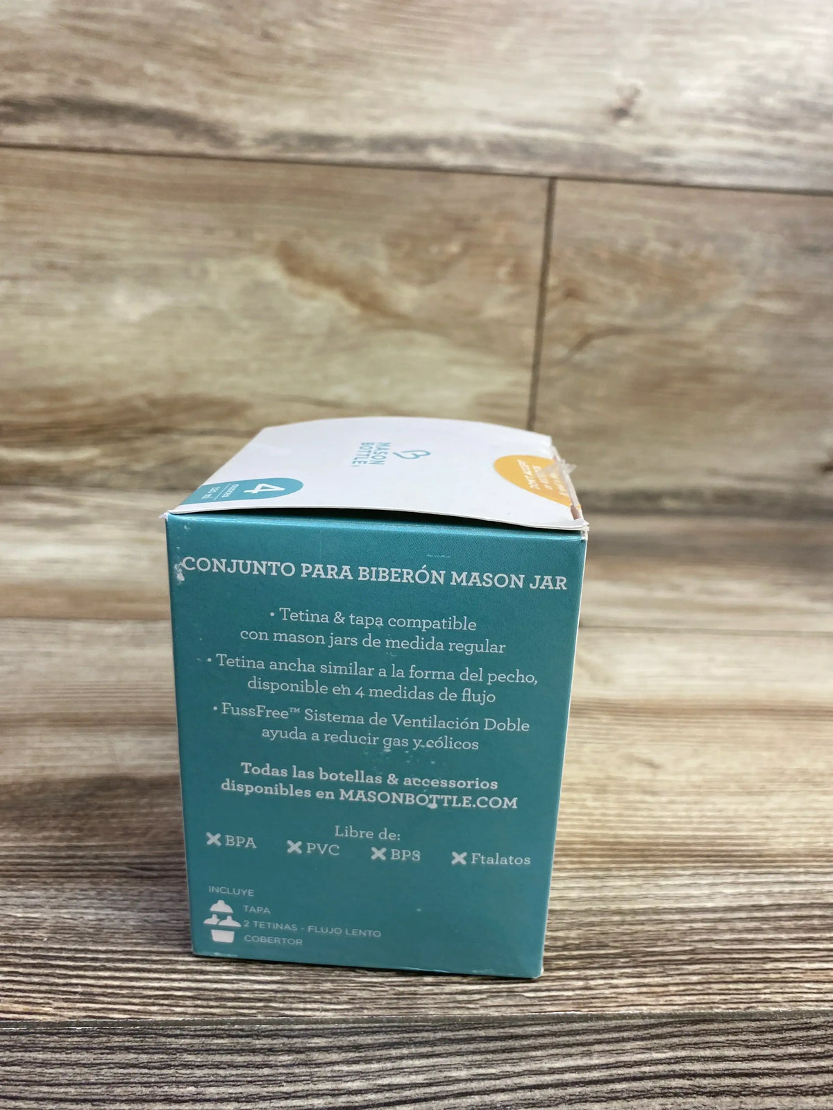 Mason jar baby bottle kit box with Spanish product details, BPA free and wooden background