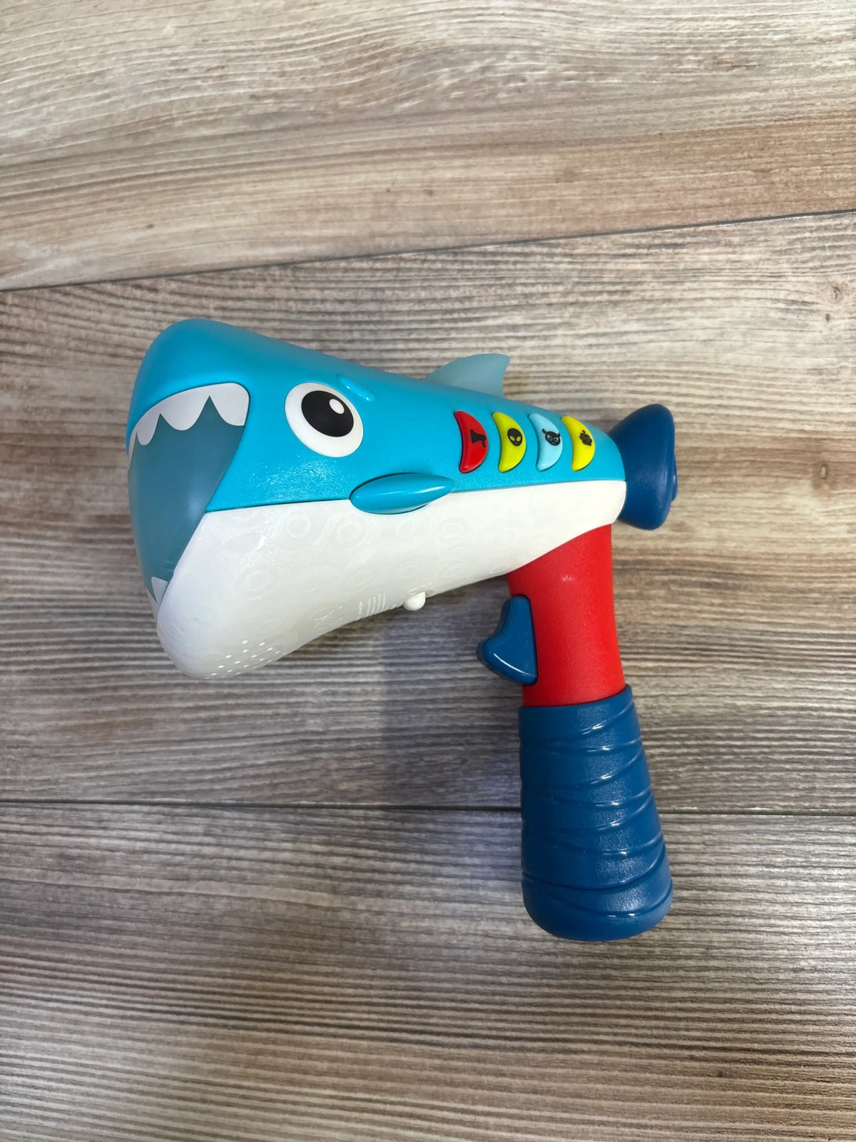 Side view of B. Toys Silly Speaker Voice Changing Megaphone showcasing shark design and colorful voice buttons on a wood surface