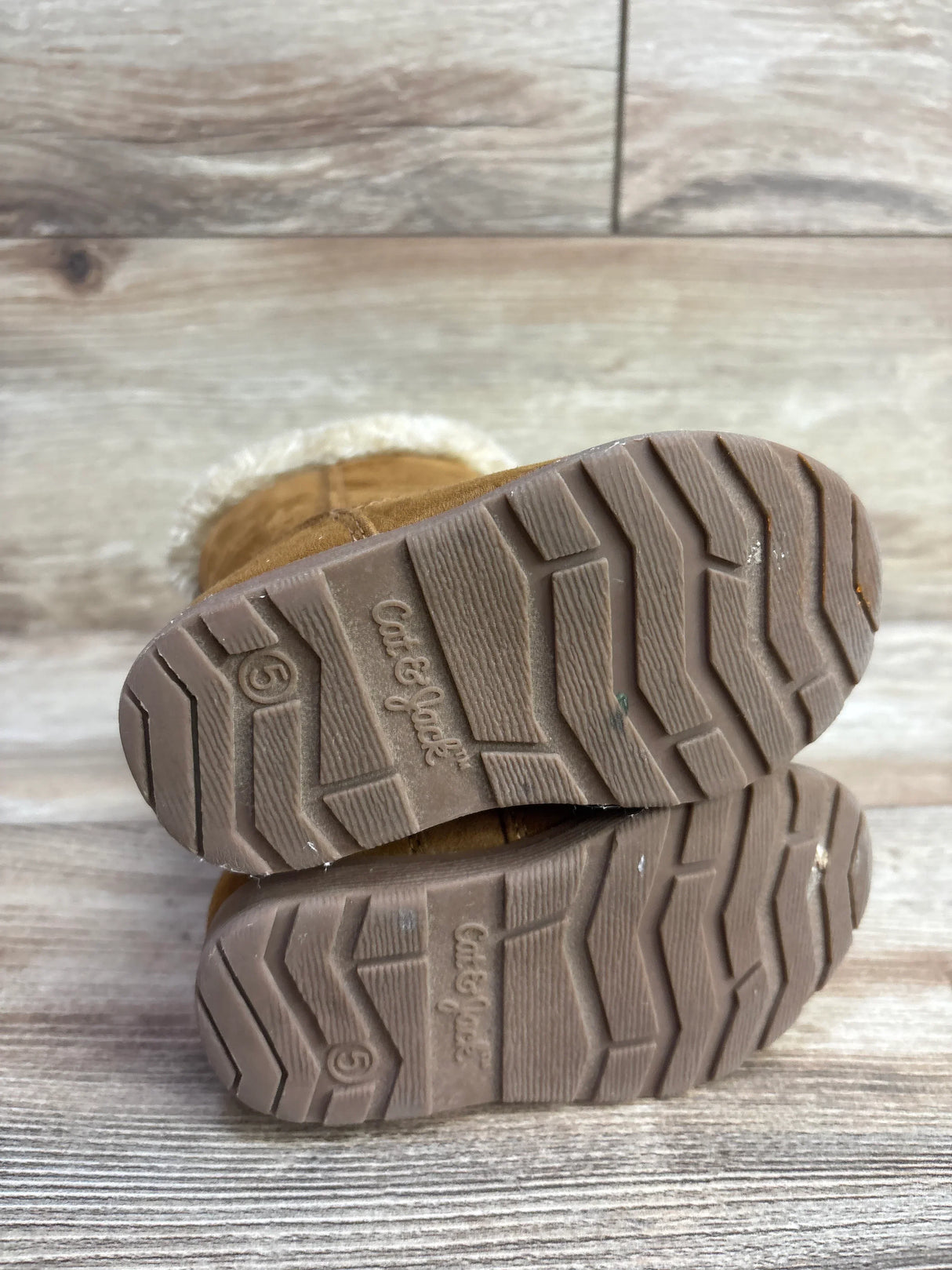 Size 5 Cat & Jack toddler brown winter boots with textured soles on wood floor