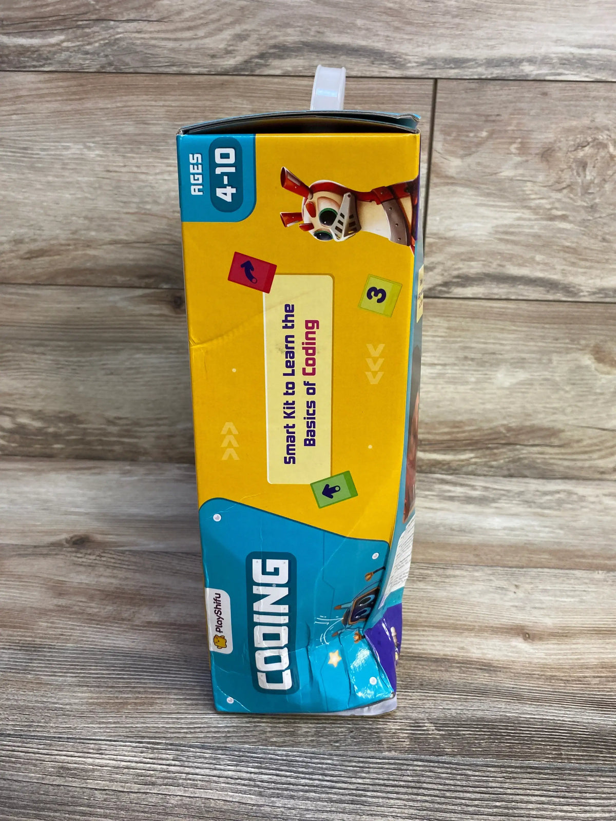 Side of Playshifu coding kit box for ages 4-10 with cartoon robot and coding basics text