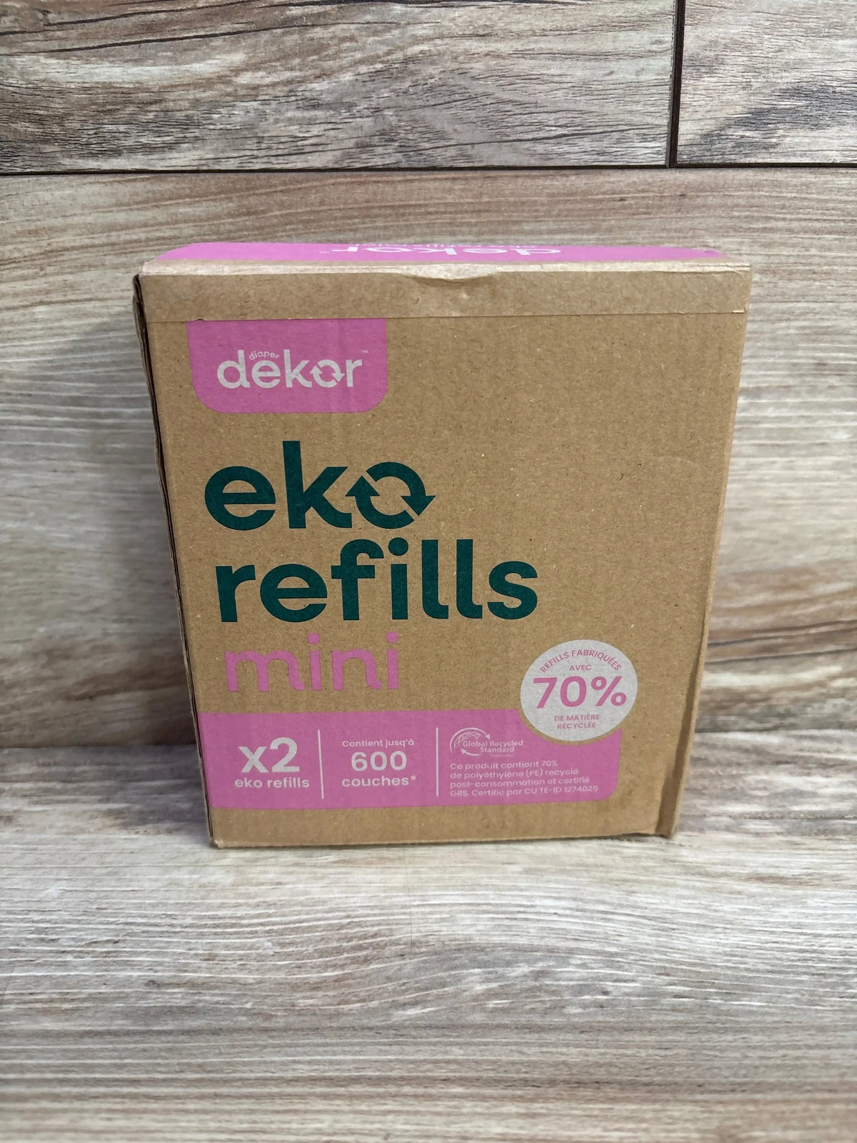 Front view of Diaper Dekor Eko Mini refill box showing eko refills mini headline, x2 pack and up to 600 couches text on wood background