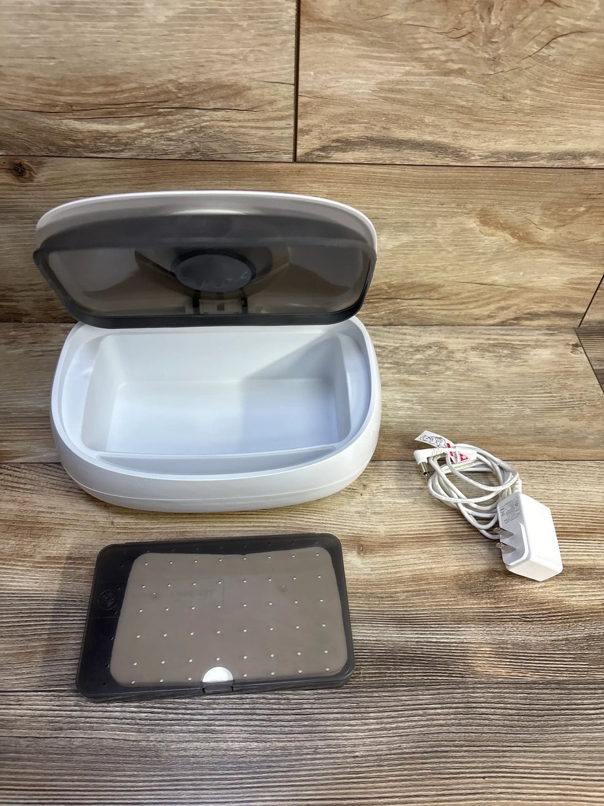 Top view of Prince Lionheart EVO Wipes Warmer showing open warmer, clear lid, perforated tray, and power cord on wood