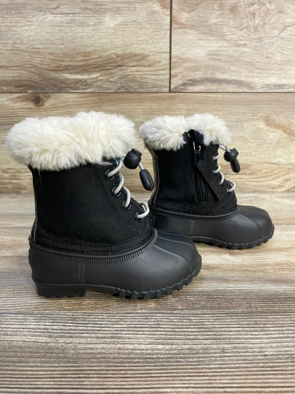 Side view of Native Jimmy toddler winter boots, black, showing faux fur cuff, rubber lower, side zipper and toggle lace