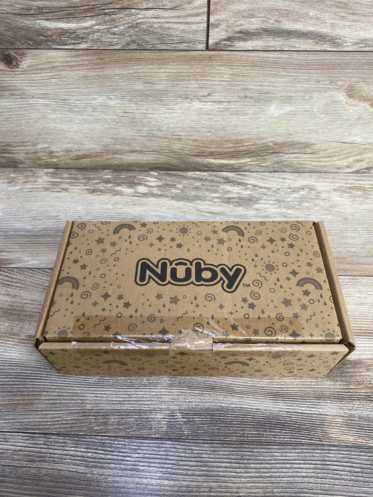 Front view of new Nuby Clik-It Grip N Sip sippy cups 3pk in sealed kraft brown box with star and moon print on wood plank floor