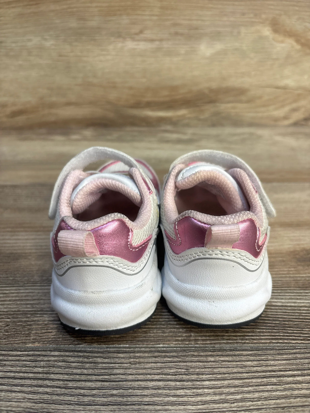 Back view of white and pink toddler sneakers on wooden floor, kids shoes resale