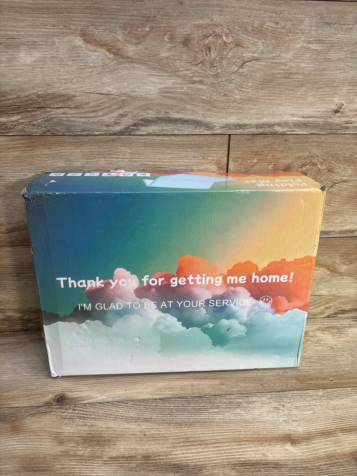 Colorful shipping box on wooden floor with thank you and service message printed on front