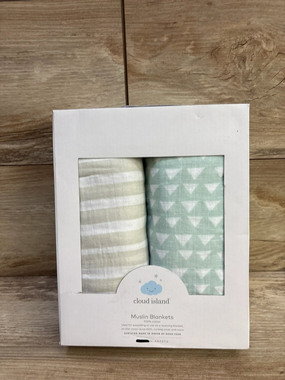 Front of Cloud Island 2-pack muslin swaddles with beige stripe and mint triangle-print in white box on wood