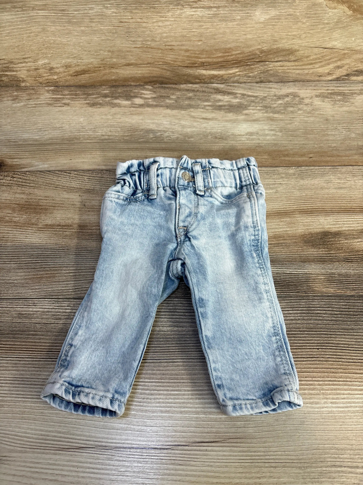 Front view of Gap Denim Just Like Mom Jeans in blue, showcasing an elastic waistband on a wooden background