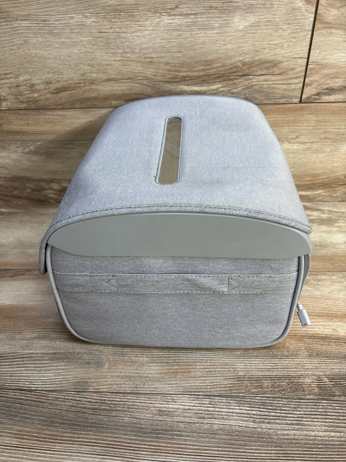 Front view of Munchkin 59S UV cleaning bag showing gray fabric zippered case, top tissue slot, and USB cable on wooden floor