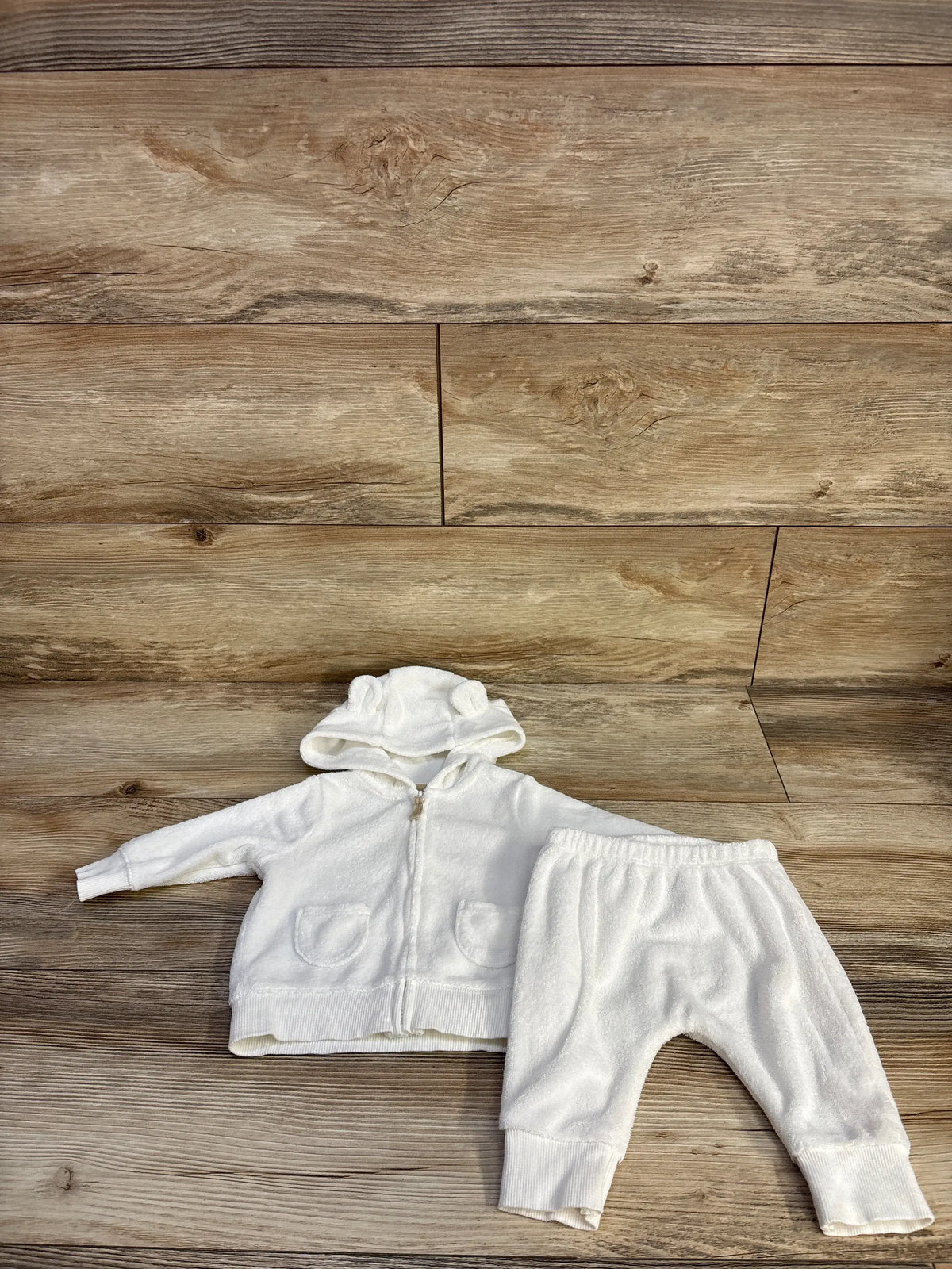 Top view of Carter’s 2-piece terry cloth hoodie and joggers set showcasing white fabric, hood, pockets, and ribbed cuffs