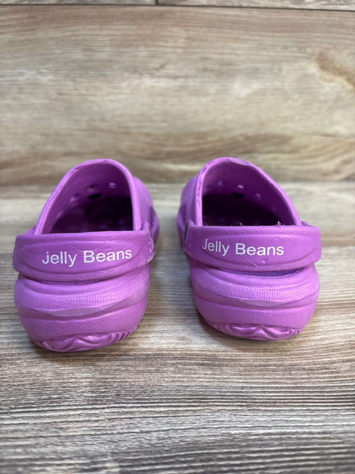 Pair of purple Jelly Beans kids shoes on wood background