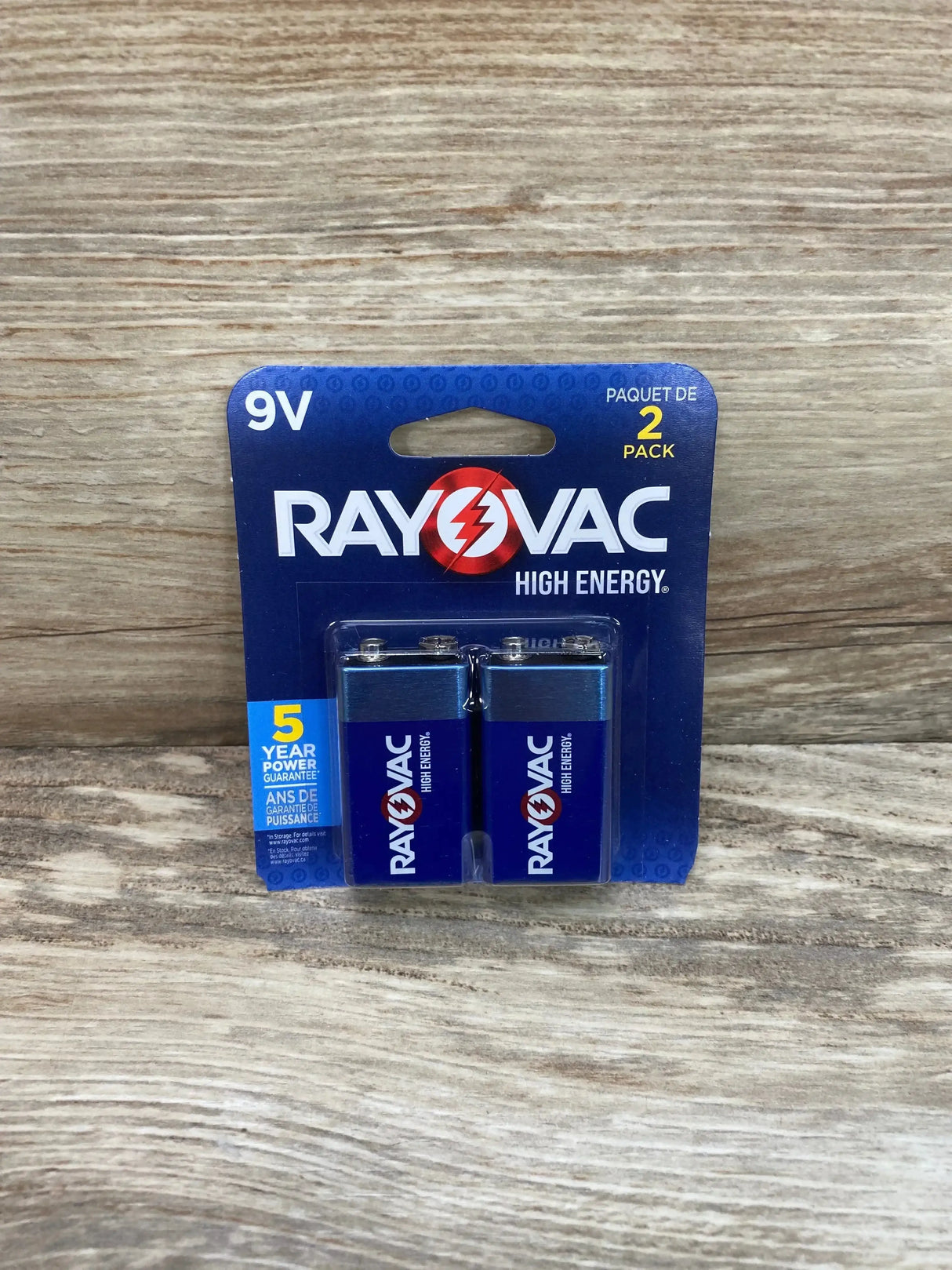 Front view of Rayovac High Energy 9V batteries two-pack in blue blister packaging on wood background