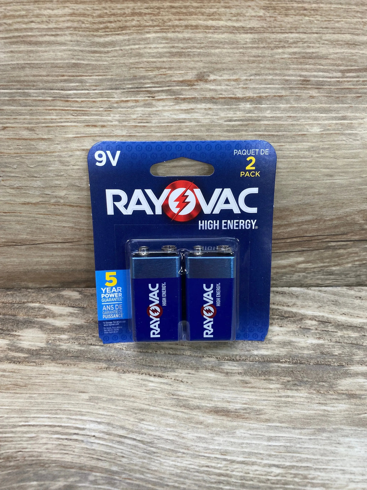 Front view of Rayovac High Energy 9V batteries two-pack in blue blister packaging on wood background