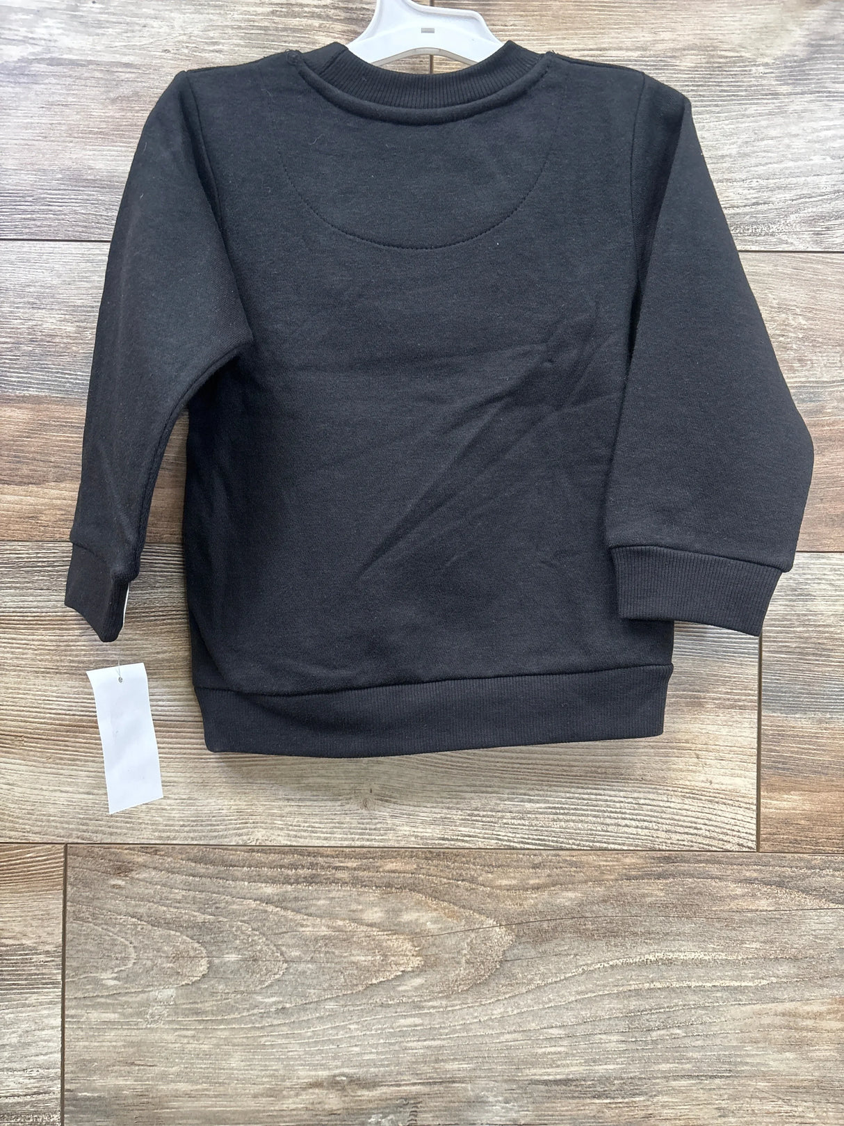 Black long sleeve toddler sweatshirt on wood background, gently used kids clothing