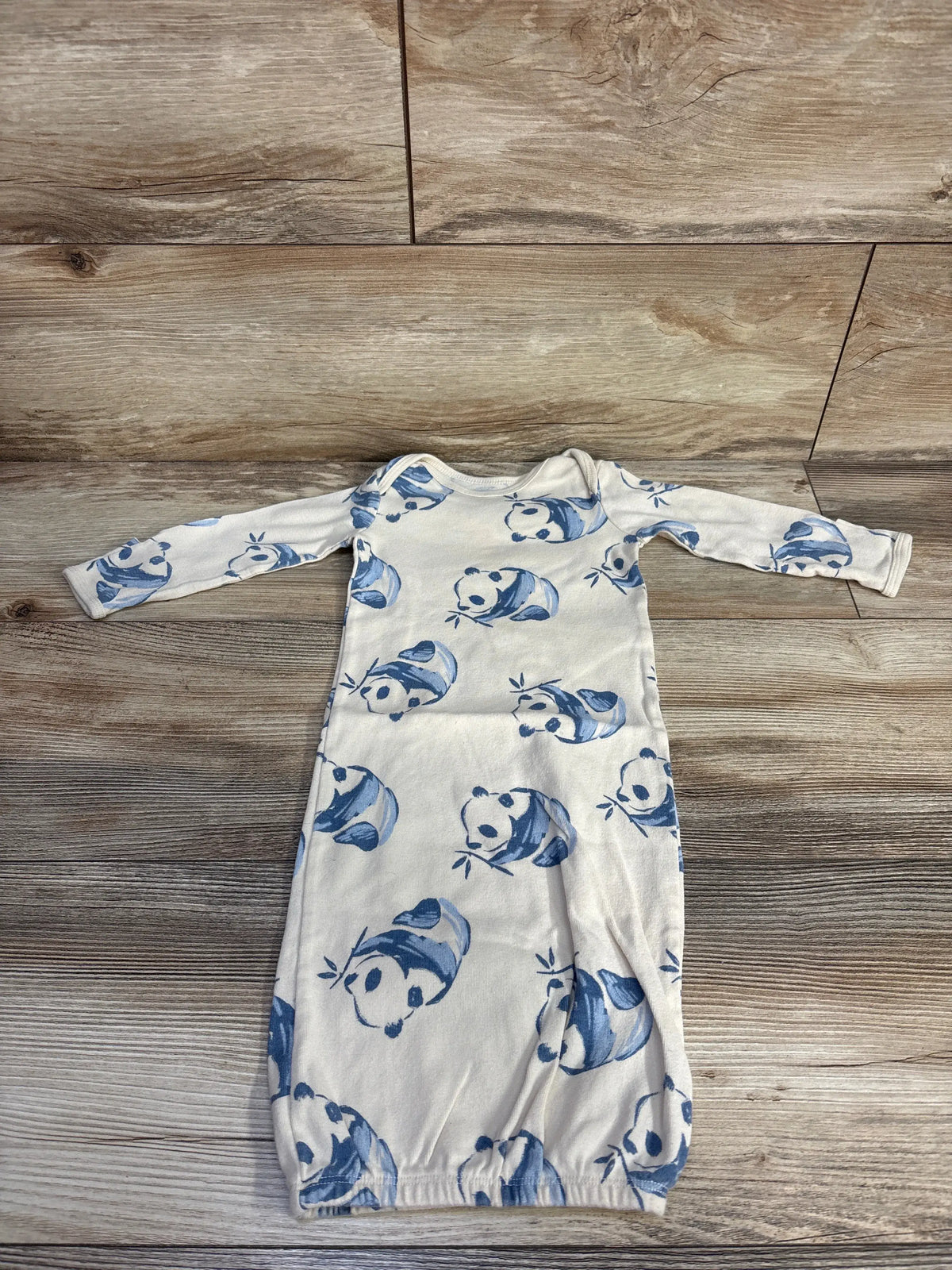 Front view of Carter’s panda print sleep gown in beige with long sleeves and gathered hem on a wood-look background