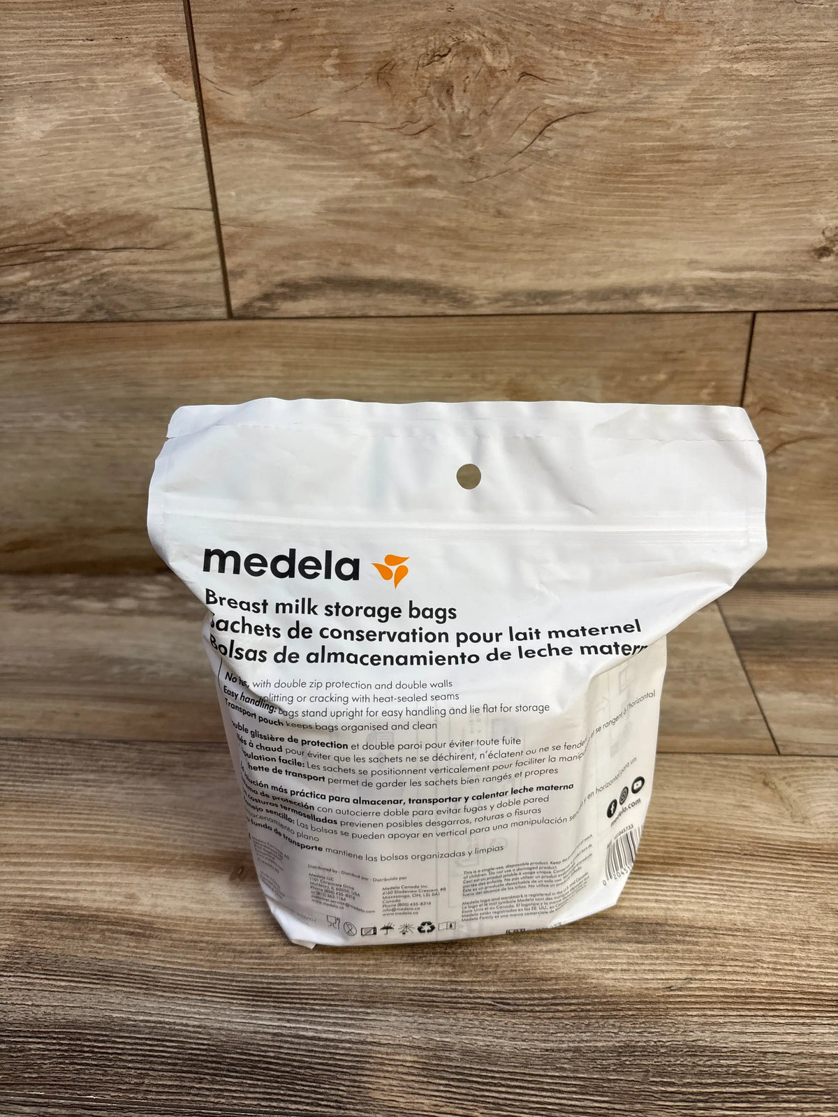 Front view of NEW Medela Breast Milk Storage Bags showcasing double-zipper protection and self-standing design on a wood floor