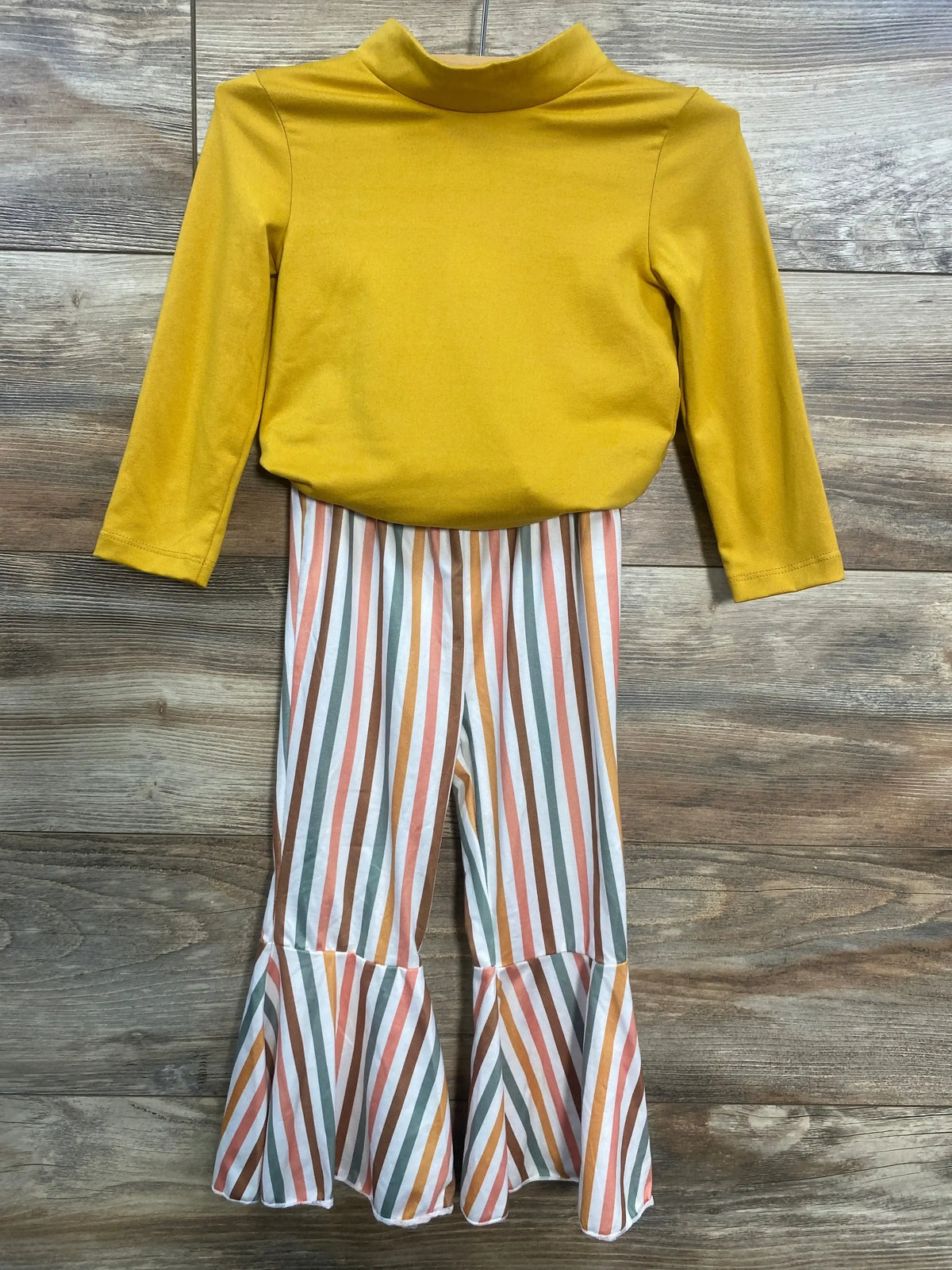 Front view of Bailey's Blossoms mustard long-sleeve bodysuit with multicolor striped bell-bottom pants, size 2T, on wood floor