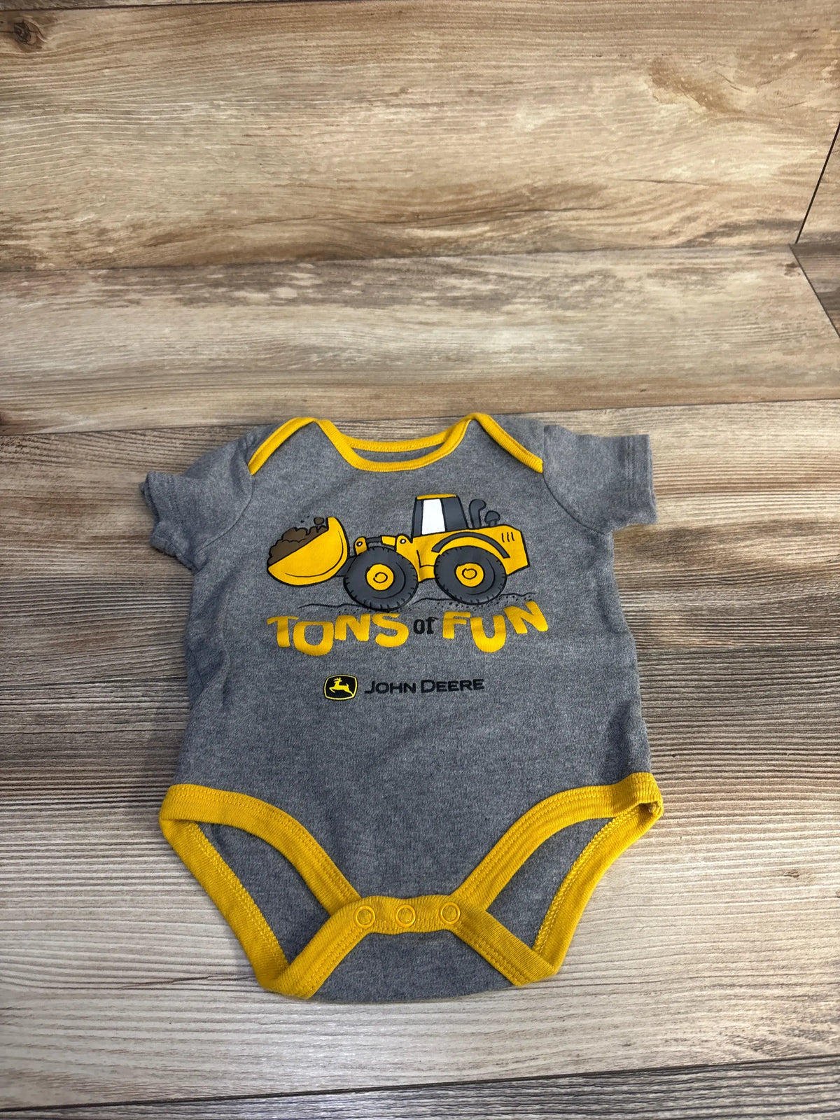 Grey Me n Mommy To Be baby bodysuit with yellow trim and a John Deere tractor graphic