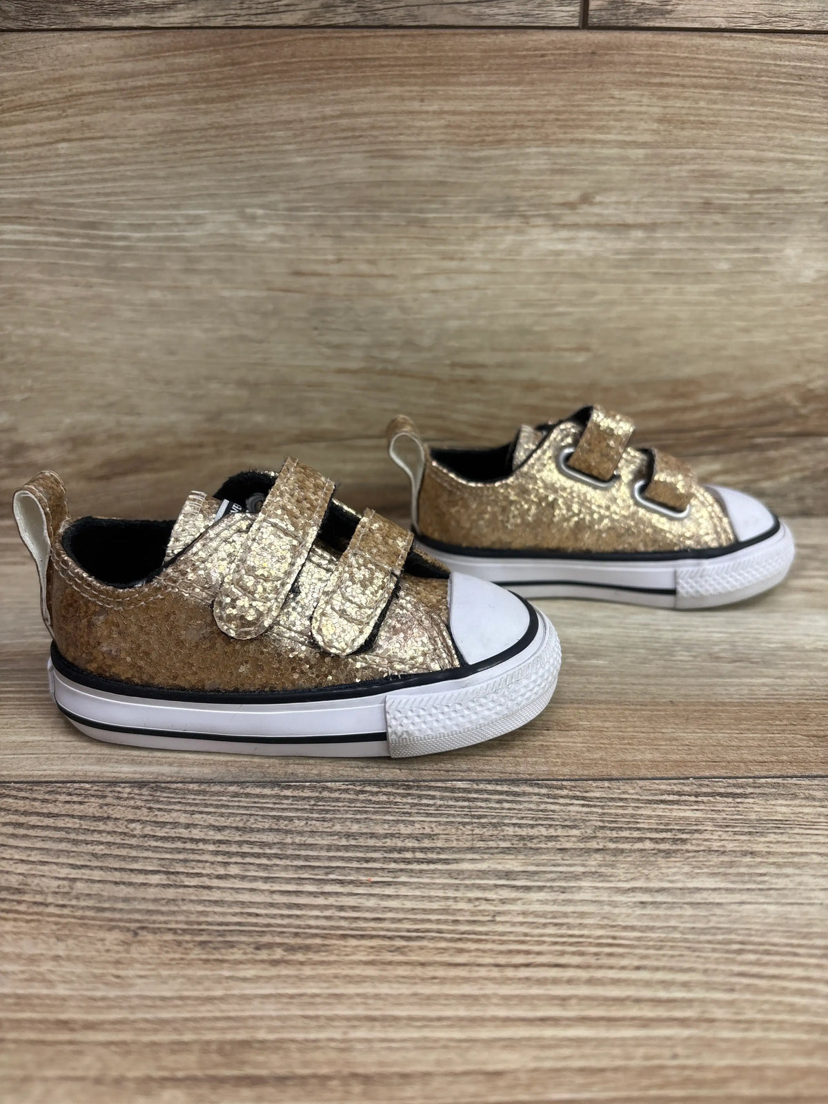 Front and side views of Converse Chuck Taylor All Star Easy-On Double Velcro sneakers showcasing gold textured uppers and white rubber soles on a wood background