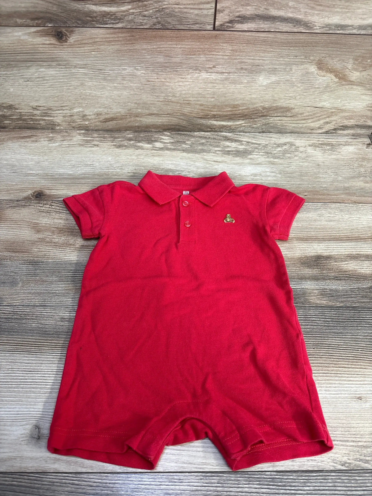 Front view of Baby Gap henley polo romper in red showcasing three-button placket and short sleeves on white background