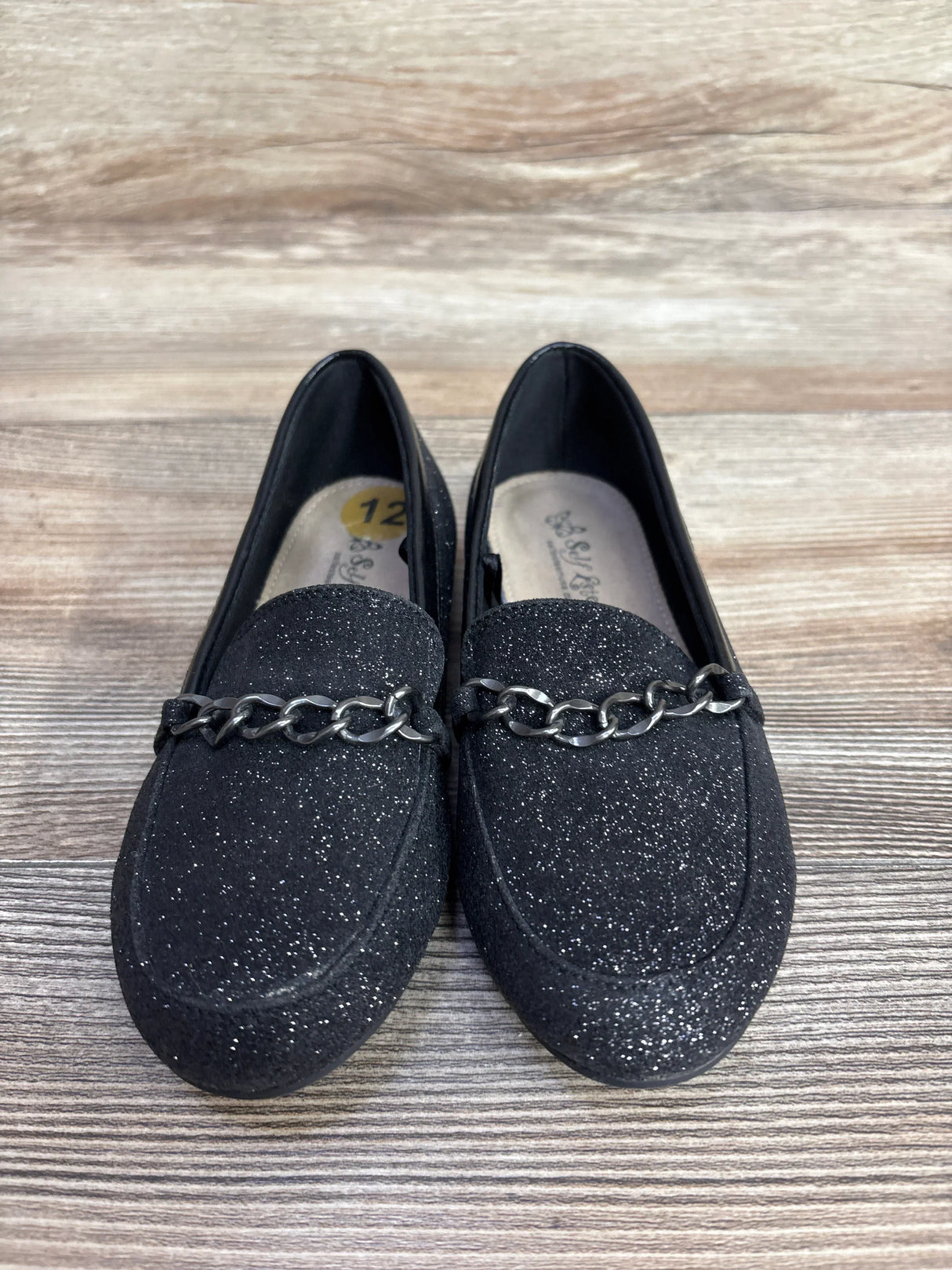 Black glitter loafers with silver chain detail on wooden floor, women's size 12 shoes