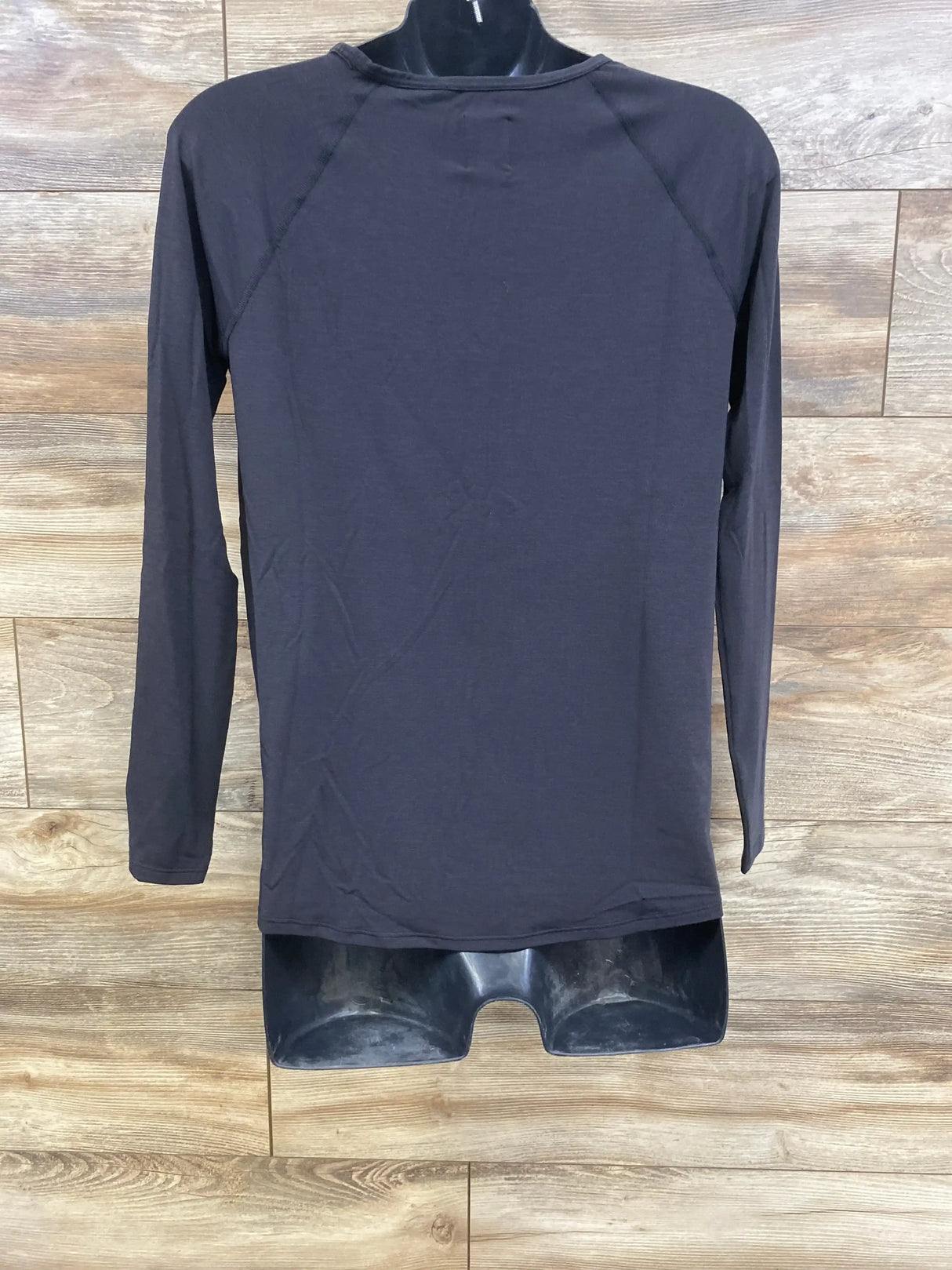 Back view of black Gap maternity long-sleeve Breathe shirt size XS showing raglan sleeves and crew neck on wood background