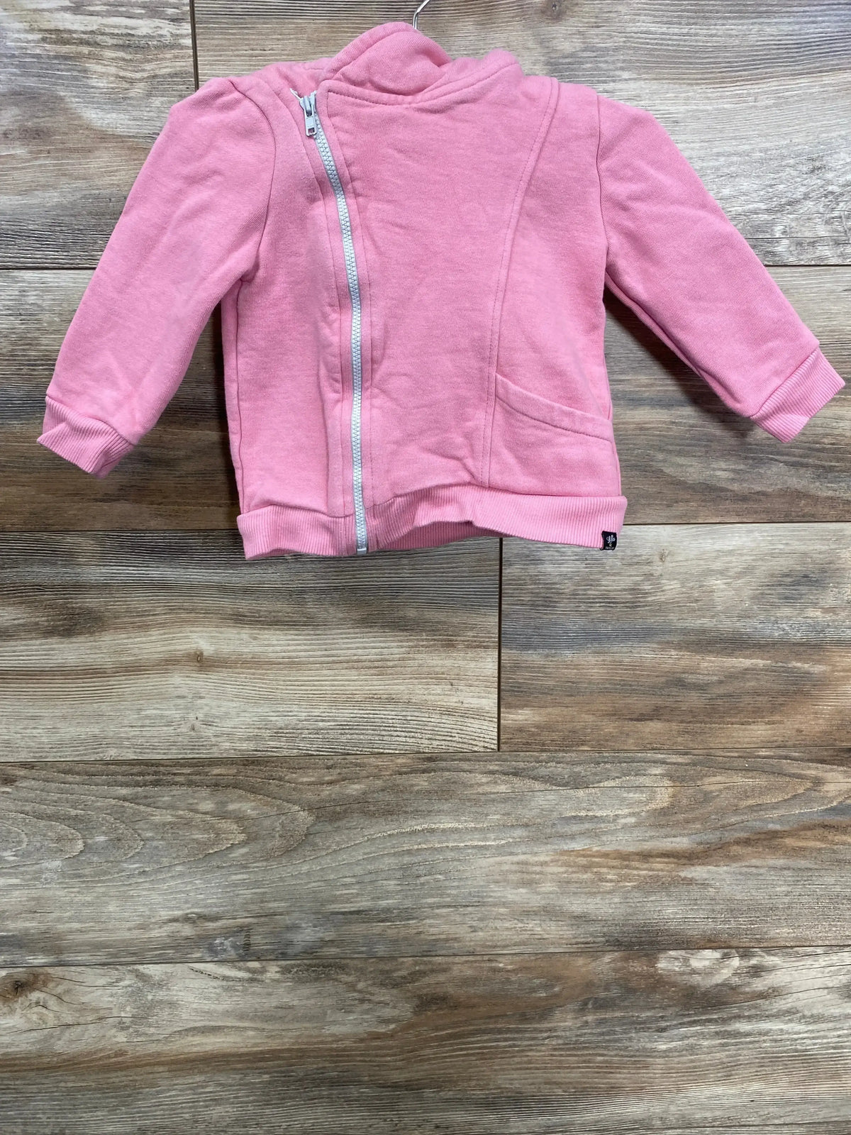 Pink toddler jacket with front zipper and pockets displayed on wooden floor