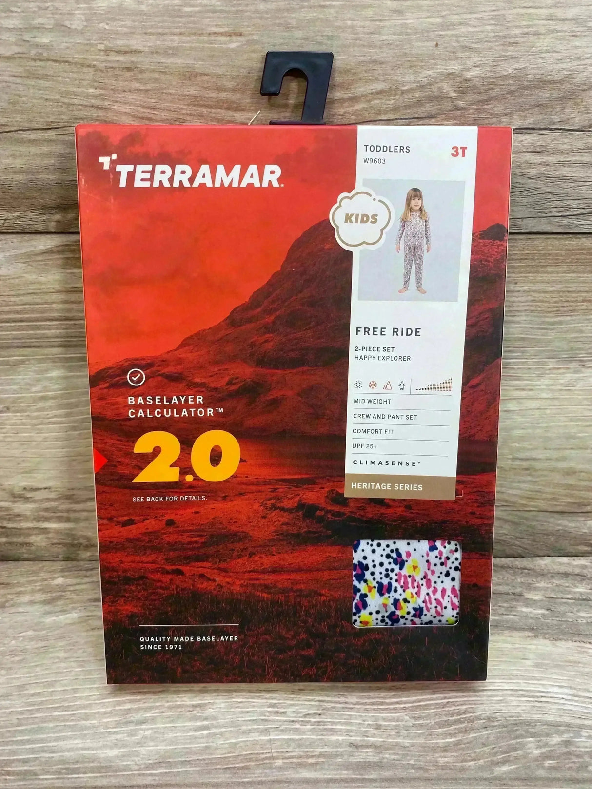 Front of Terramar 2-piece mid-weight base layer set (3T) showcasing speckled white crew-and-pant pattern visible through packaging on wood background
