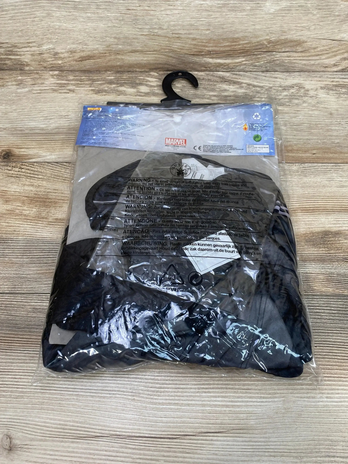 Packaged view of Rubie’s Marvel Captain America costume in size 8 to 10 inside a clear plastic bag on a wood surface