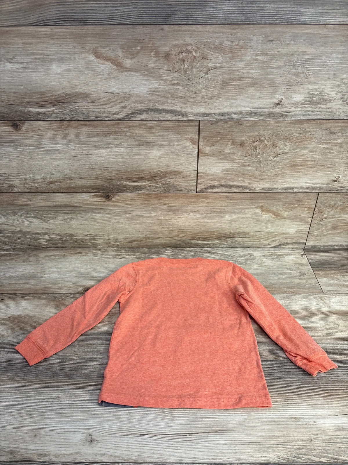 Back view of Carters race car shirt showcasing heathered orange long sleeve tee on wood plank floor