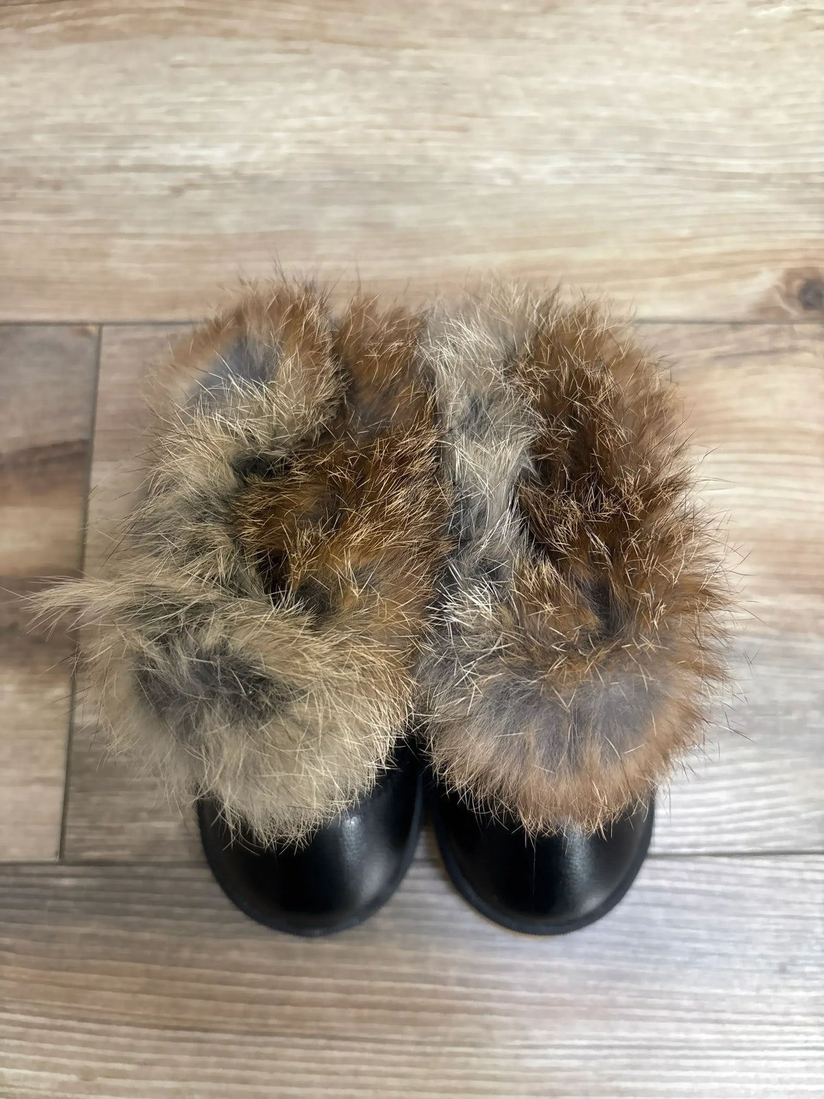 Black toddler boots with brown faux fur trim on wooden floor