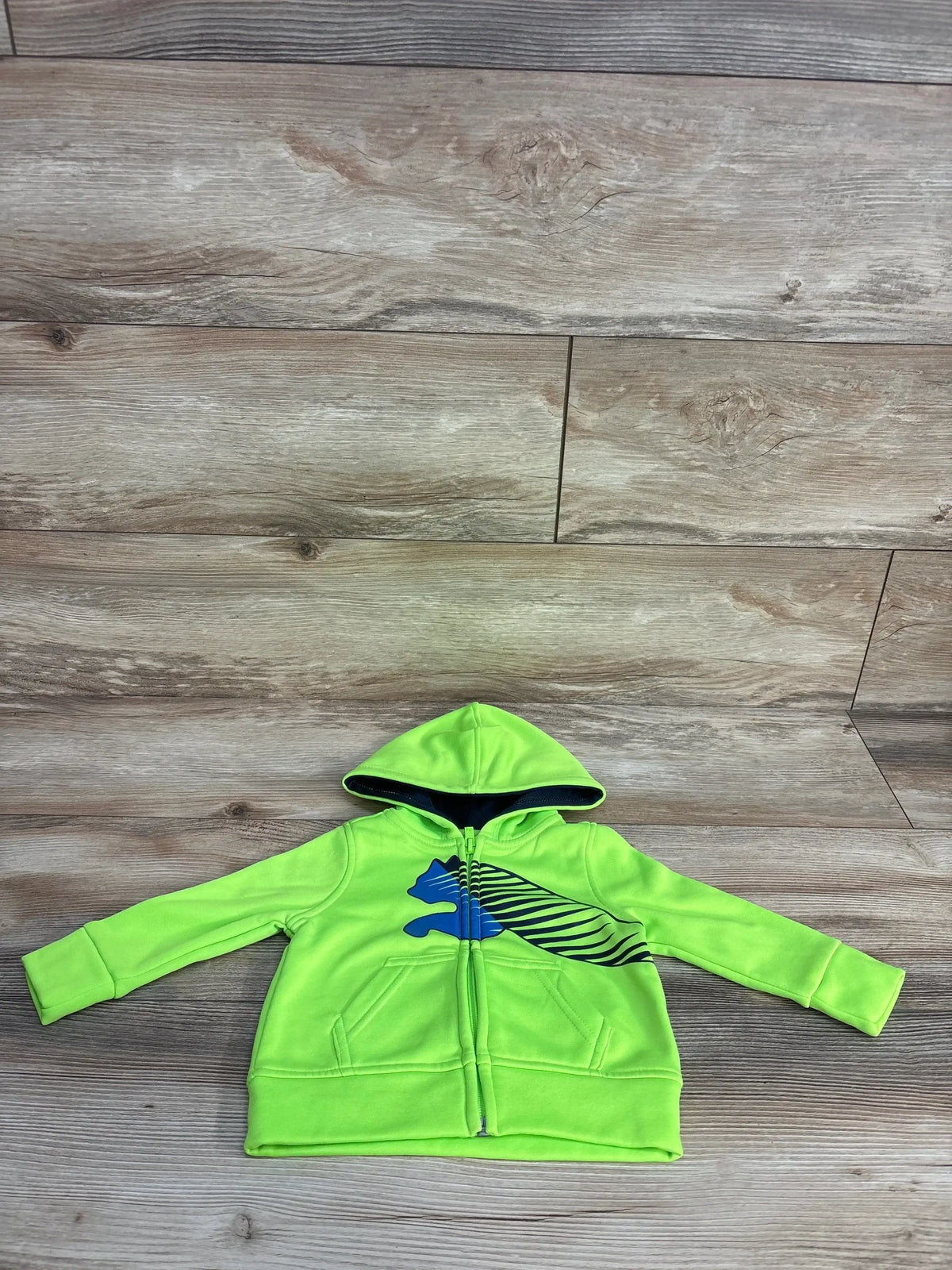 Bright green toddler hoodie with blue and black puma logo on wooden floor