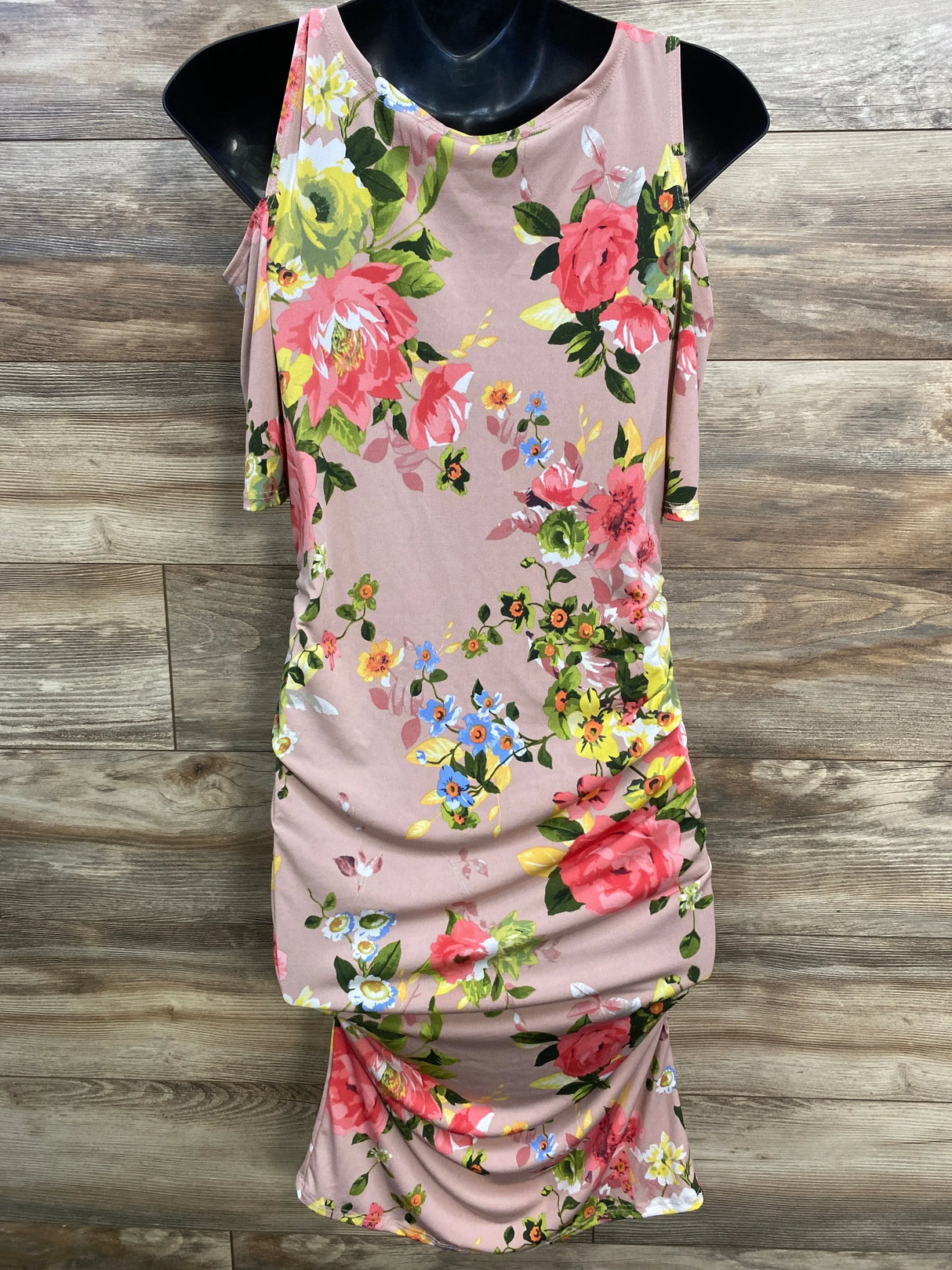 Pink floral bodycon dress with colorful flowers, sleeveless, on mannequin, wood background