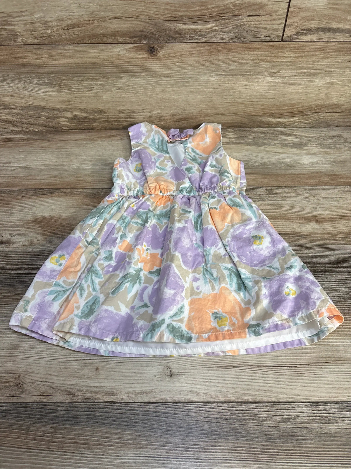 Flat lay of Carter's 3T sleeveless floral dress, pastel purple and peach print, keyhole back on wood background