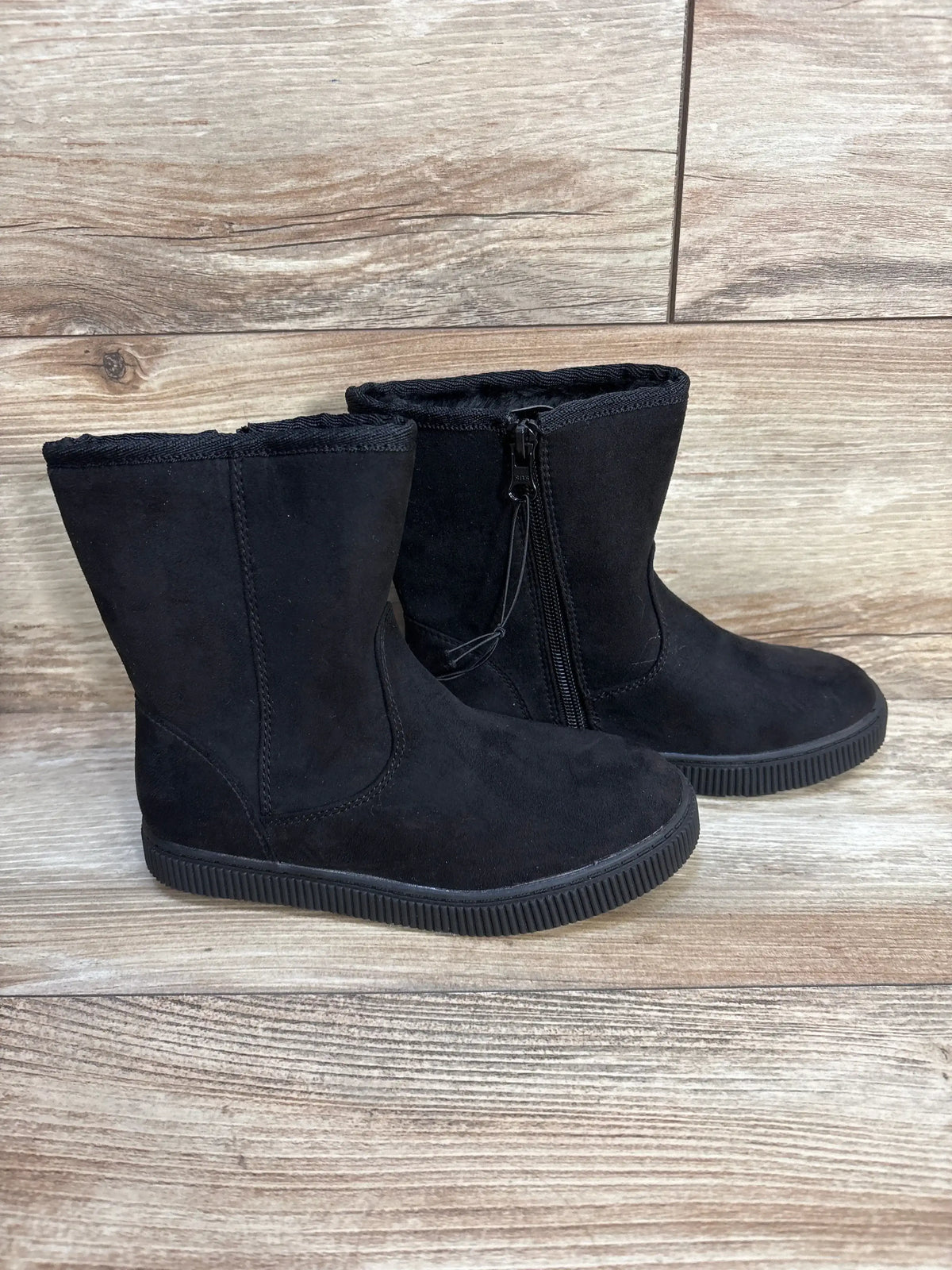 Three-quarter view of Cat and Jack Pip kids black boots with faux suede upper side zipper and shearling lining on wood floor