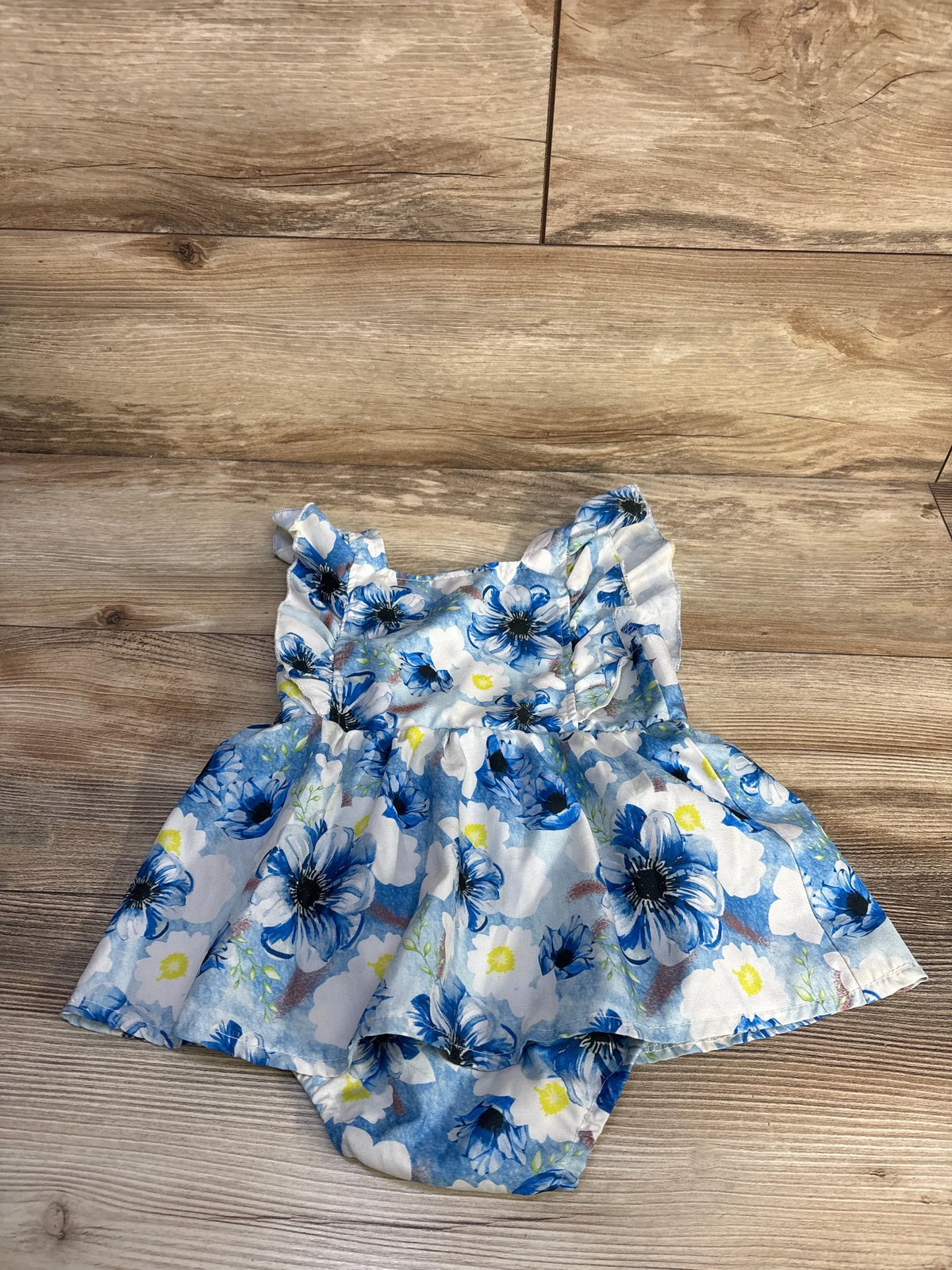 Front view of EYIIYE fly sleeve bodysuit dress showcasing blue floral print with a wooden background