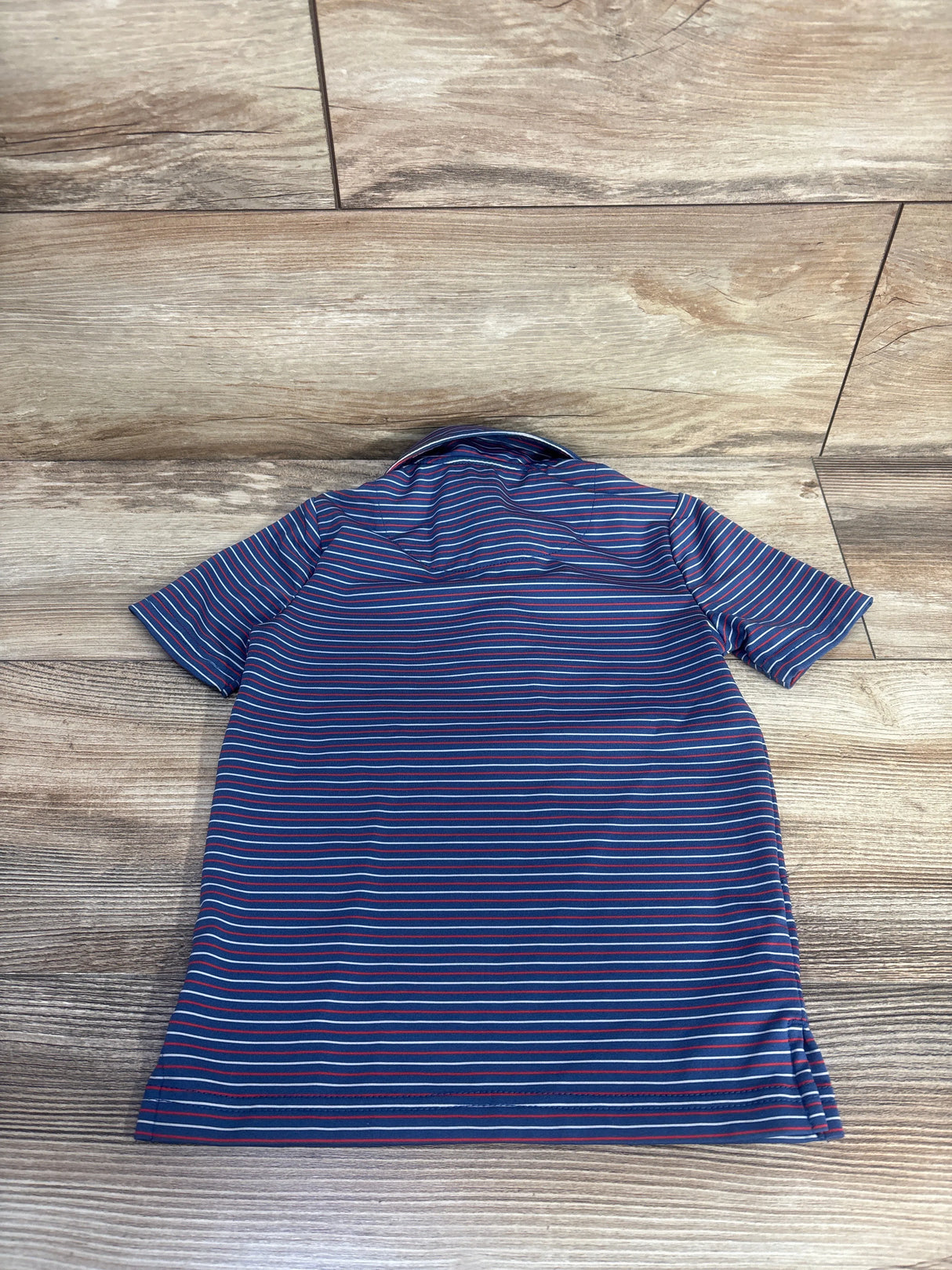 Back view of Class Club Stripe Synthetic Polo Blue showcasing stripes, short sleeves, and polo collar on a wood floor